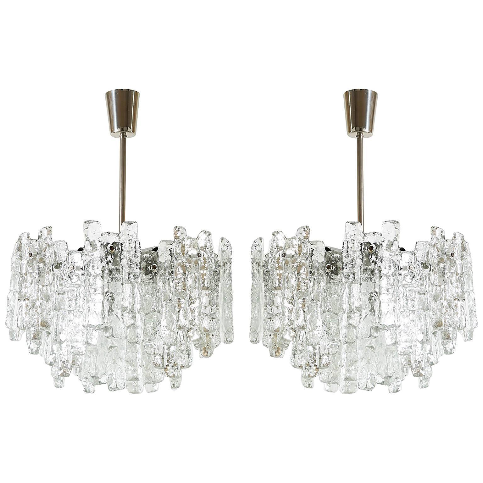 One of two beautiful ice glass light fixtures by Kalmar, Austria, manufactured in midcentury, circa 1970 (late 1960s or early 1970s). Each chandelier is made of 28 massive ice blocks which are mounted on a silver painted metal frame. Stem and canopy