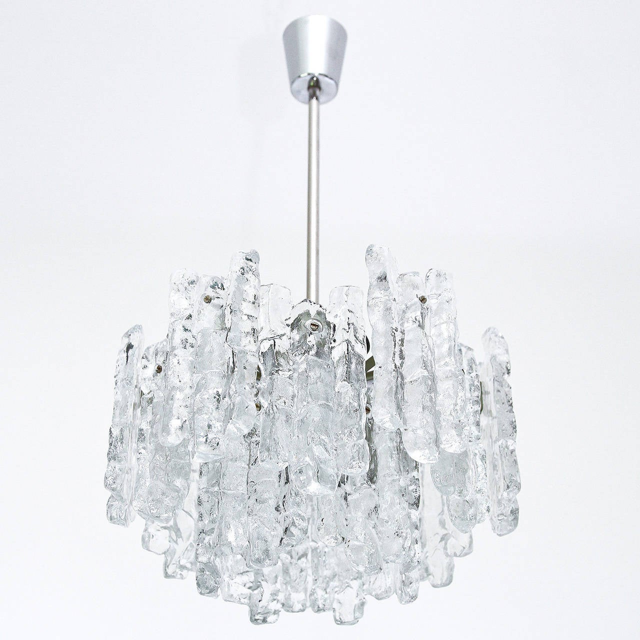A beautiful ice glass light fixtures by Kalmar, Austria, manufactured in midcentury, circa 1970 (late 1960s or early 1970s). The chandelier is made of 18 massive ice blocks which are mounted on a silver painted metal frame.
The fixture takes six