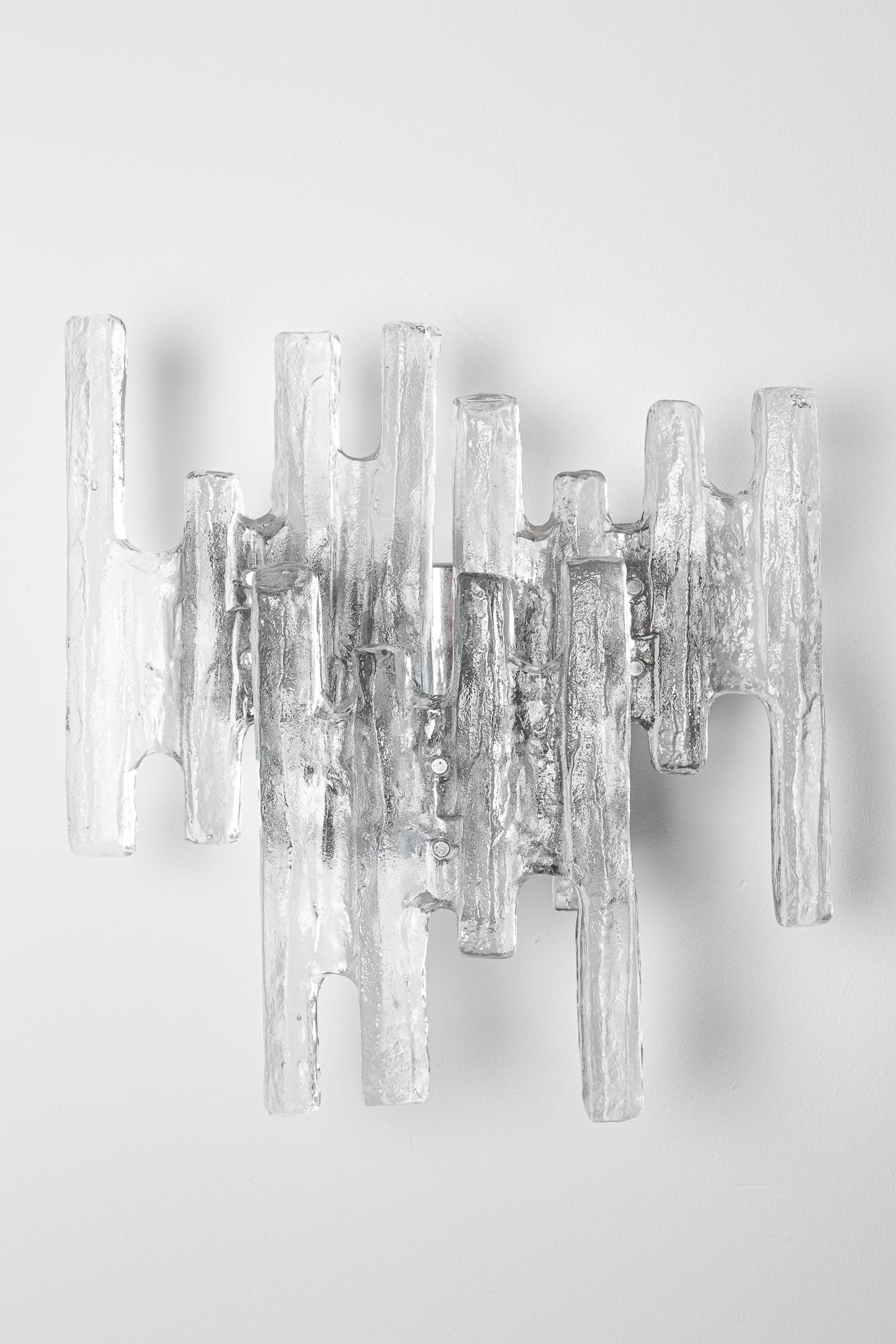 A Kalmar wall sconce. The sconce has three parts of glass. They are in different positions. The glass is very fresh. It look like Ice and is called ice -glass. Very transparent glass with white 