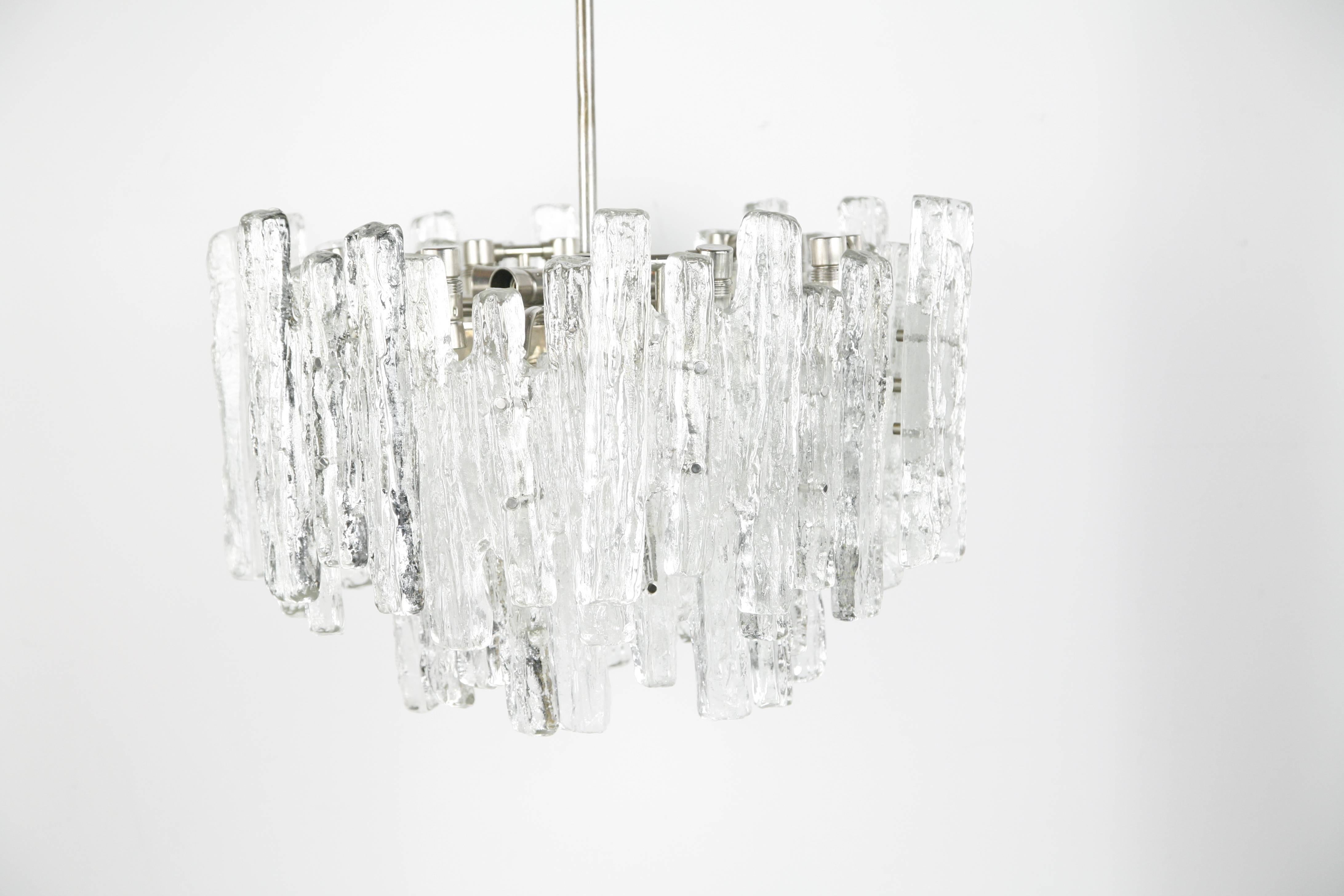 Kalmar matte ice glass chandelier from the 1960s, Austria.
A metal frame holding 18 pieces of thick ice looking glass with a matte organically shape, the inside of the glass is clear and flat, there is six original European light sources that