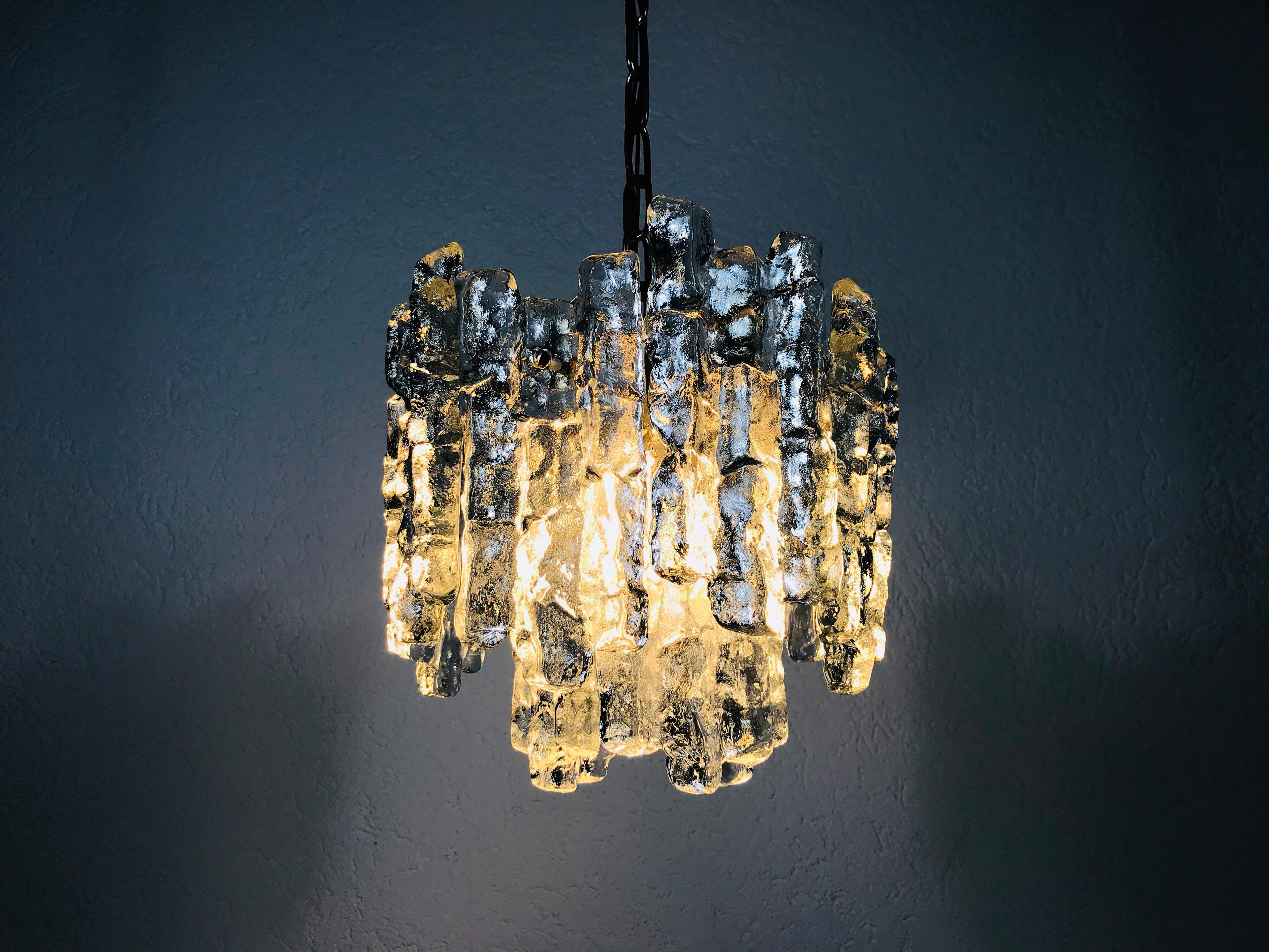 This is a beautiful ice glass chandelier from Kalmar Franken made in Austria in the 1960s. It is a fascinating lighting with a beautiful design. The frame and the chain are of full brass. Two-tier ice glass shade. 

Measurements:

Total height: