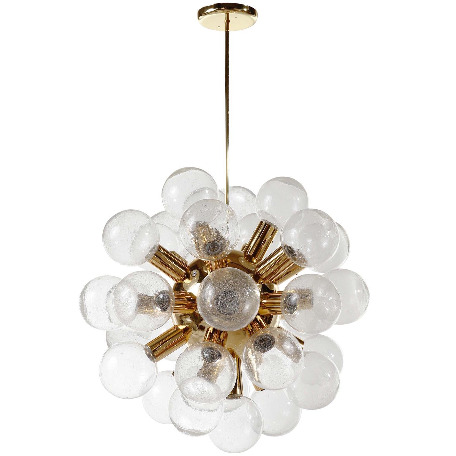 A rare and large 27-arm atomic chandelier or pendant light model 'RS 27 Kugel HL' by J.T. Kalmar, Austria, manufactured in midcentury, circa 1970 (late 1960s or early 1970s).
It is made of brass plated aluminum and 27 handblown bubble glass lamp