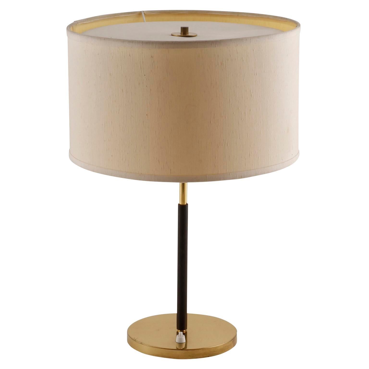 A table lamp by J.T. Kalmar, manufactured in midcentury, circa 1970 (late 1960s or 1970s).
It is made of a brass covered base, a covered stand with dark brown leather, brass fittings.
The shade is renewed on base of the original one. They will be