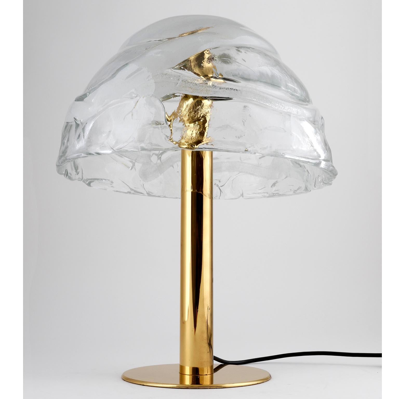 A brass and Murano glass table light model 'Dom' by J.T. Kalmar, Austria, manufactured in midcentury, circa 1970 (late 1960s or early 1970s).
A large hand blown lampshade made of textured clear crystal glass with a white bubble spiral is held by a