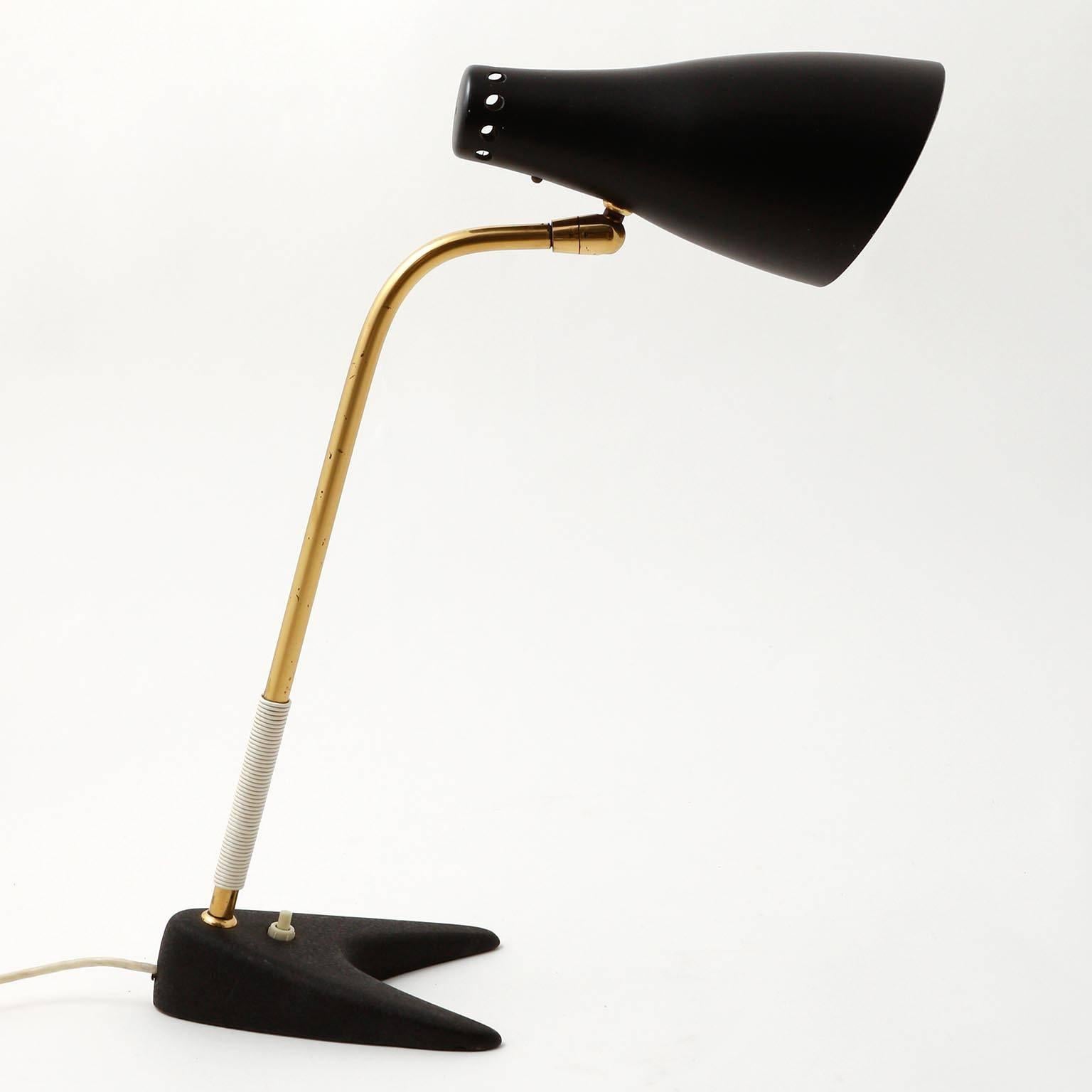 A table lamp with model name 'Stilfix' and no. 1257 by J.T. Kalmar, manufactured in midcentury, circa 1960 (late 1950s or early 1960s).
The light is made of a black cast iron base, a brass stand with a white grip made of a plastic string and a