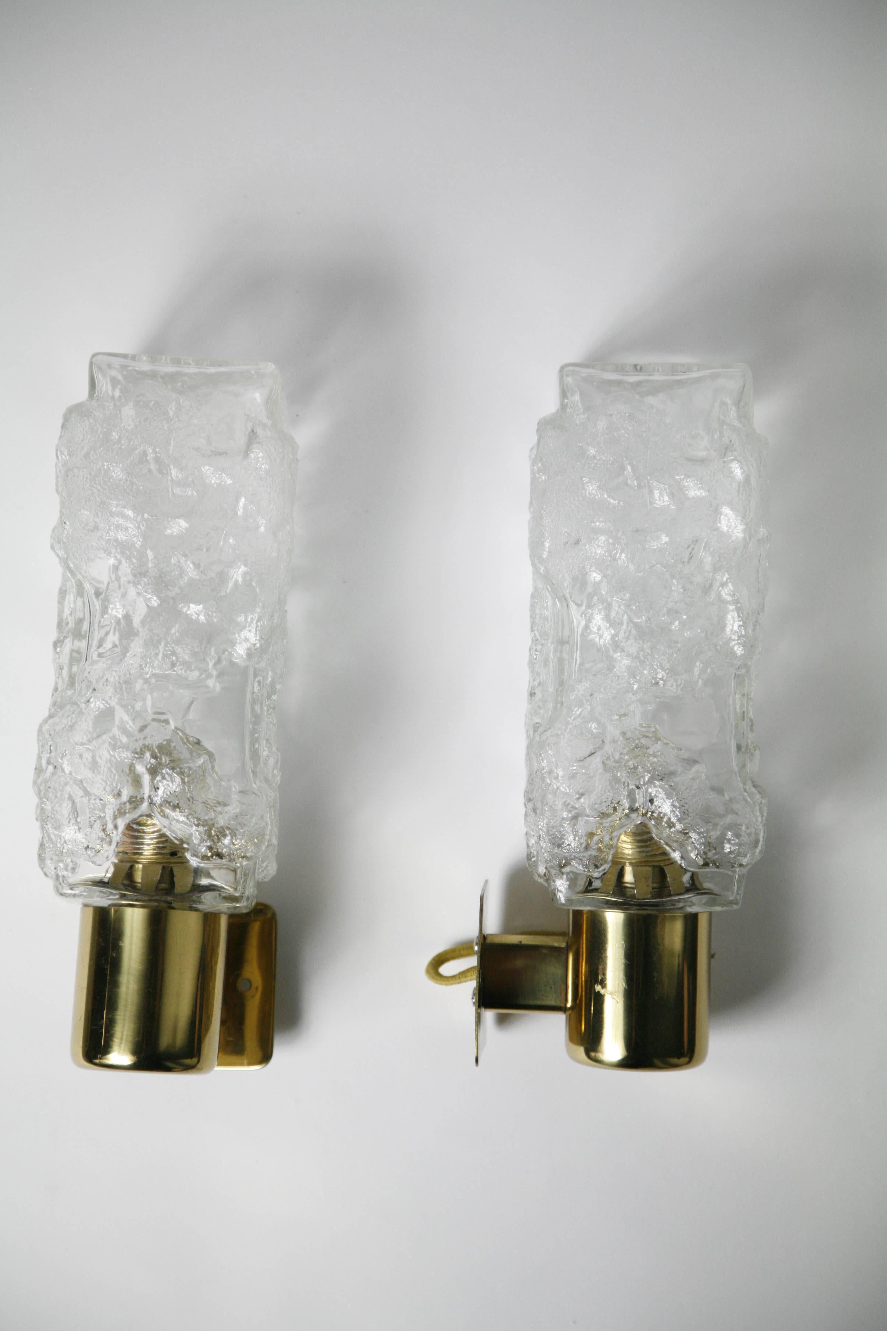 Kalmar wall lights gold and glass shades, 1970 Austria Vienna
Pair of Kalmar brass wall lights on a steel frame with gold/brass plating a square hollow glass with organically shaped pattern to the glass holds one European candelabra socket.
This