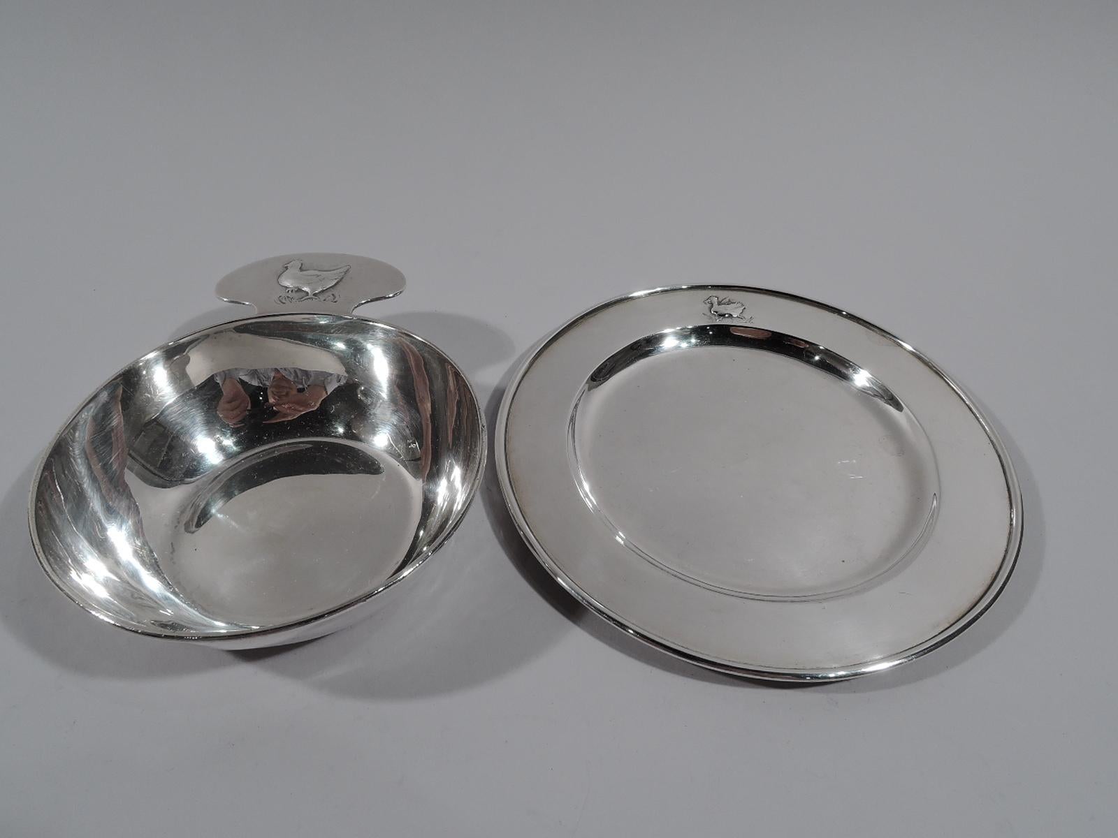 American craftsman sterling silver porringer and plate. Made by Kalo in Chicago. Porringer has round and tapering body with shaped and solid handle. Plate is round with well. Embossed farmyard animals. On porringer handle is a mother hen and on
