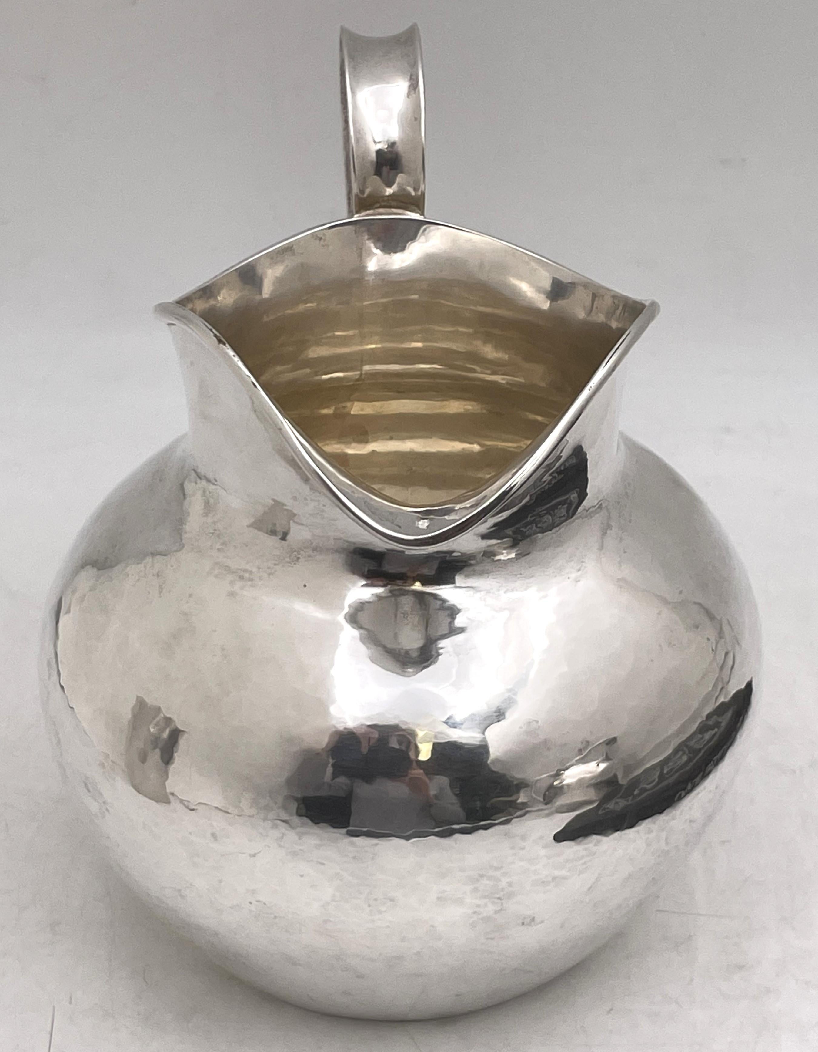 The Kalo Shop, sterling silver beautifully hand wrought pitcher in Arts & Crafts style in an elegant, curvilinear design made in the early 20th century. It measures 7'' in height by 8'' from handle to spout, weighs 18.9 troy ounces, contains 3 1/2