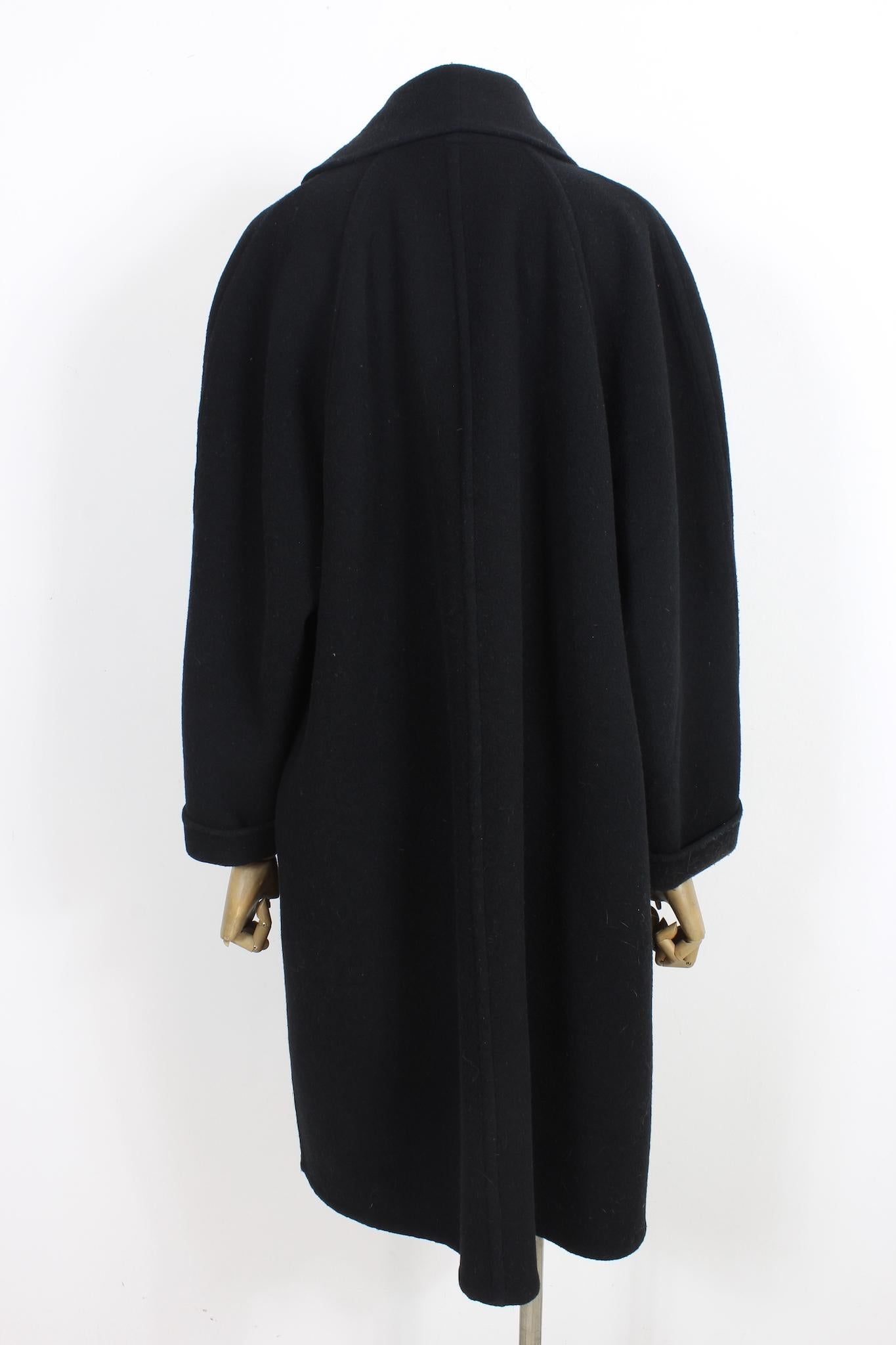 Kamanta 80s vintage oversized coat. Enveloping cape model, black colour, 100% wool fabric. Internal button closure. Made in Italy.

Size: 44 It 10 Us 12 Uk

Shoulder: 46 cm
Bust/Chest: 60 cm
Sleeve: 59 cm
Length: 112 cm