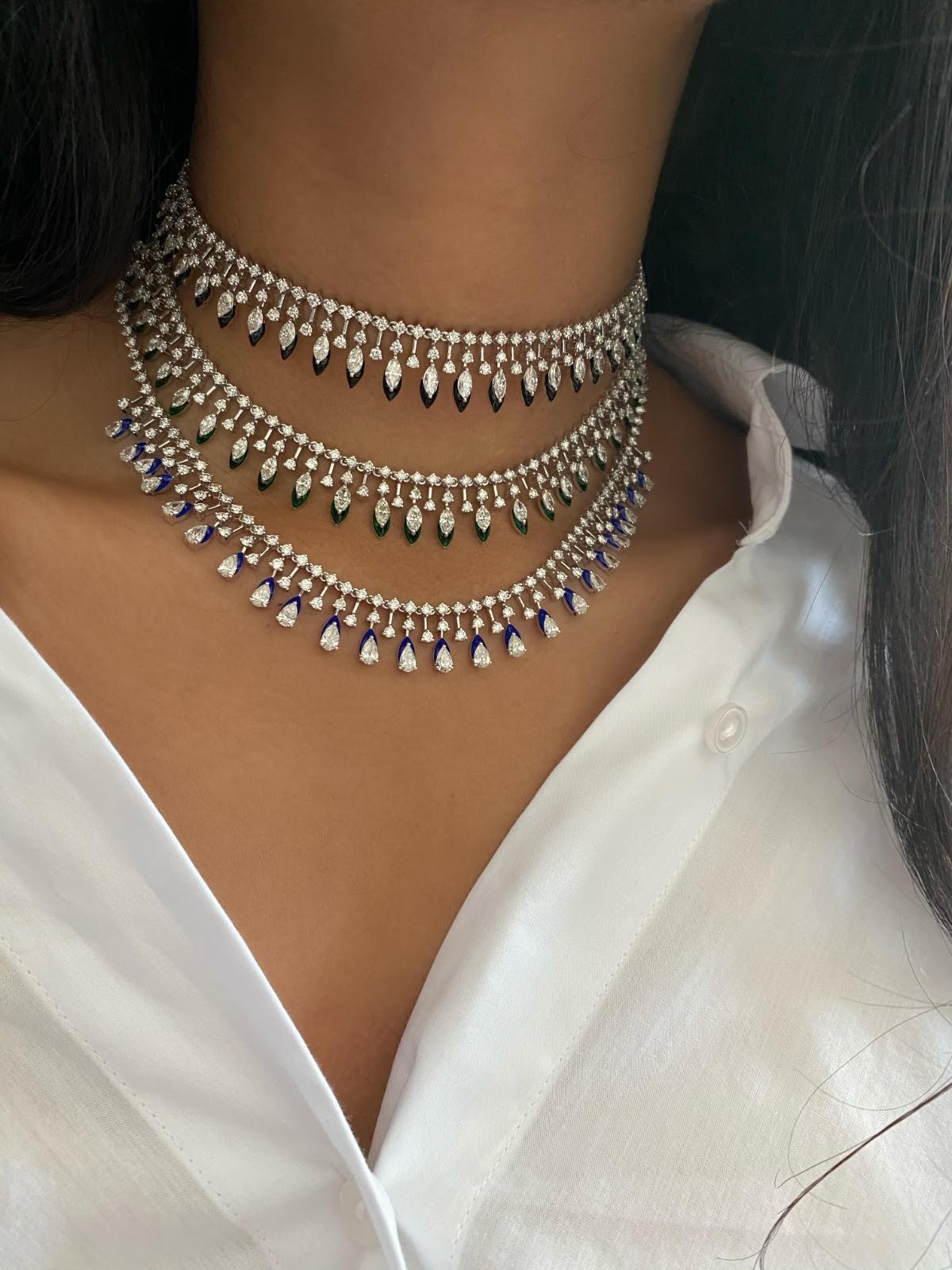 Graduating pear shape diamonds from 0.25 carats to 0.10 carats, in combination with 0.05 carat round diamonds. Navy Blue enamel is used to highlight the pear shapes. This choker is made in 18k white gold, and has a self adjustable ball chain