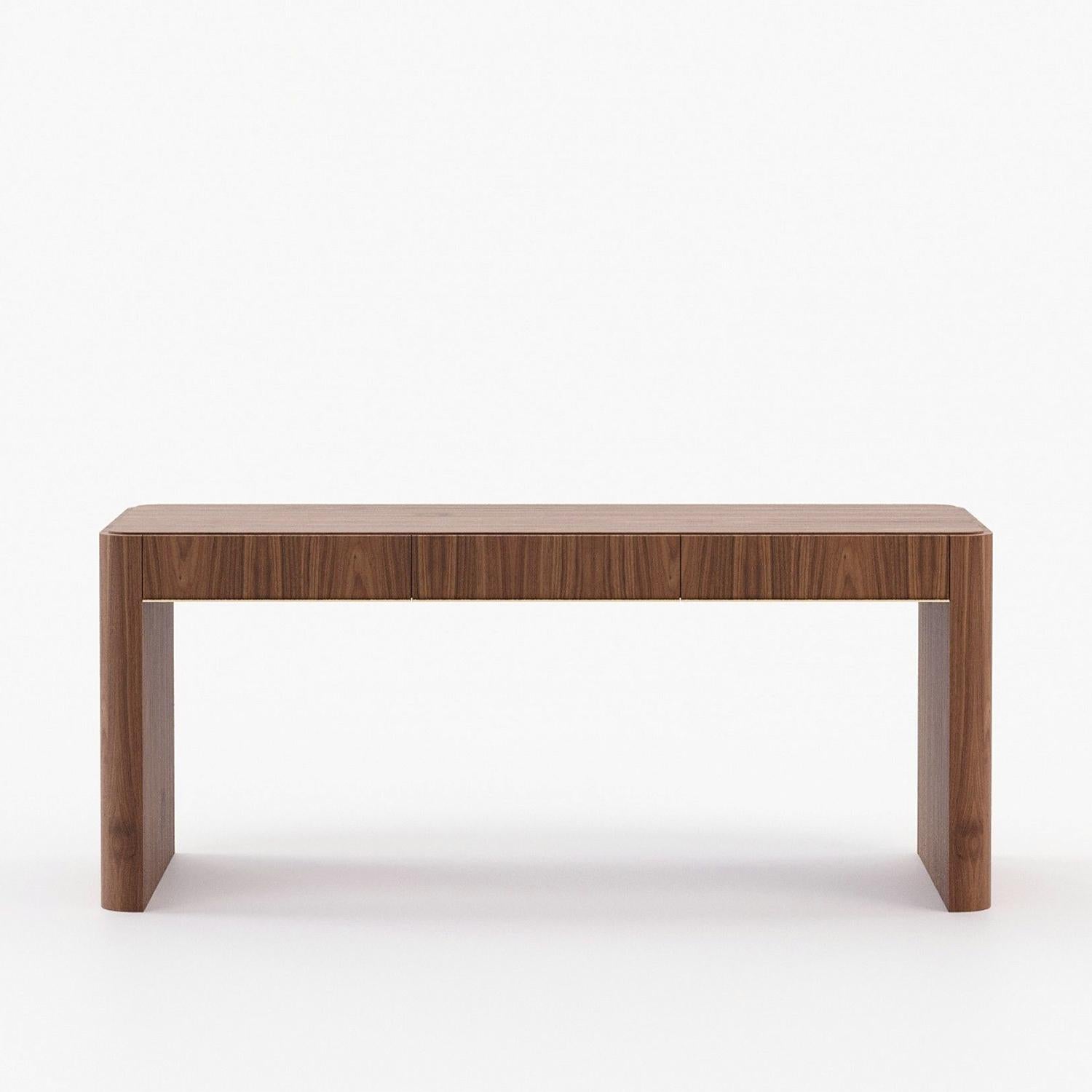 Schreibtisch Kanam mit Holzstruktur in Nussbaum matt fiinsh, 
mit polierter Edelstahlverkleidung in Goldoptik. Mit 3 Schubladen
mit Easy-Glide-System.
Auf Anfrage auch in Eiche grau matt, in Eiche natur oder in
Ebenholz, mattiert. 
Auf Anfrage und