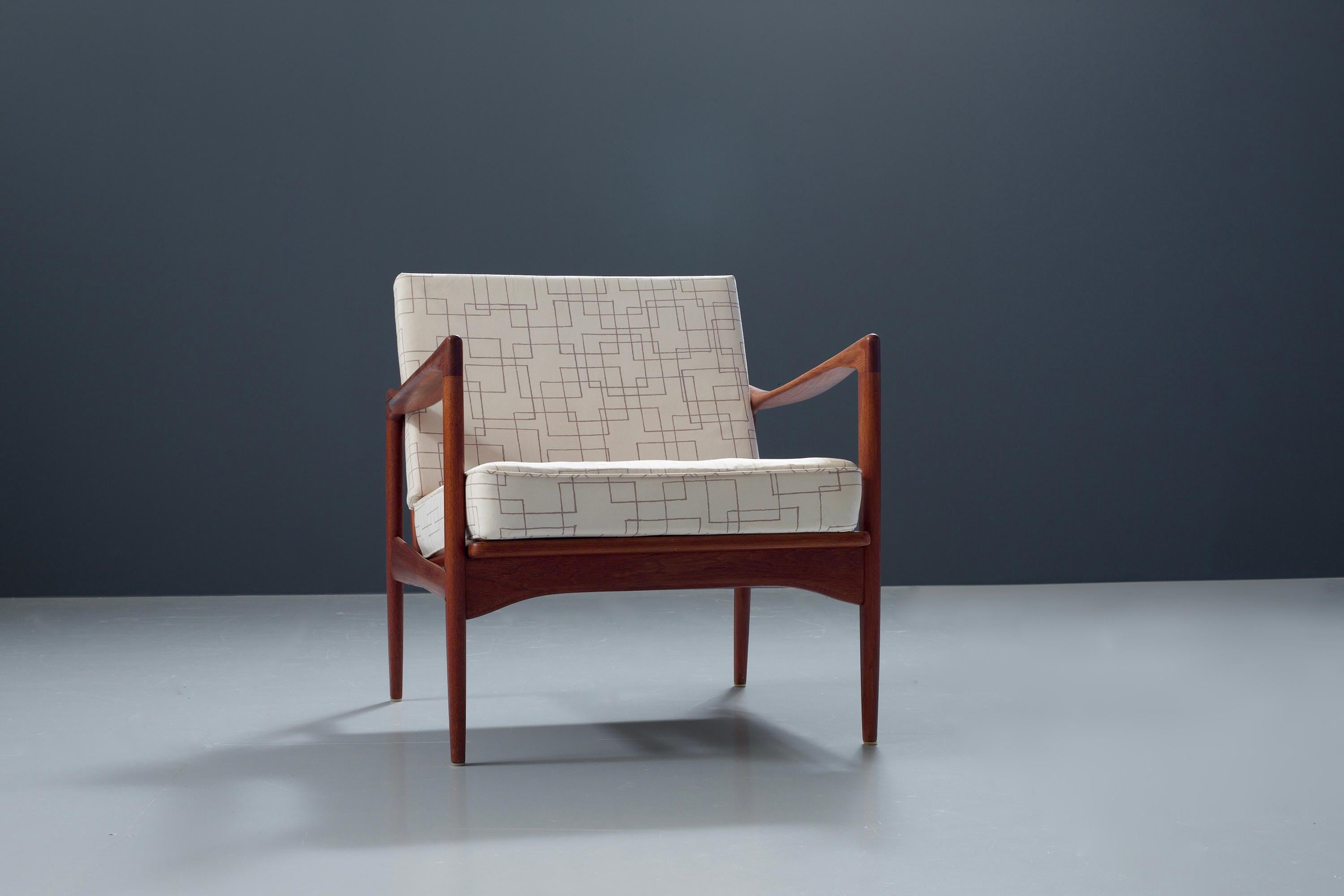 'Kandidaten' chair by Ib Kofod-Larsen in well preserved teak that has colored into nice dark brown over the years. Very typical for the work of Larsen are the shapes of the armrests that you also see back in different models such as the Elisabeth