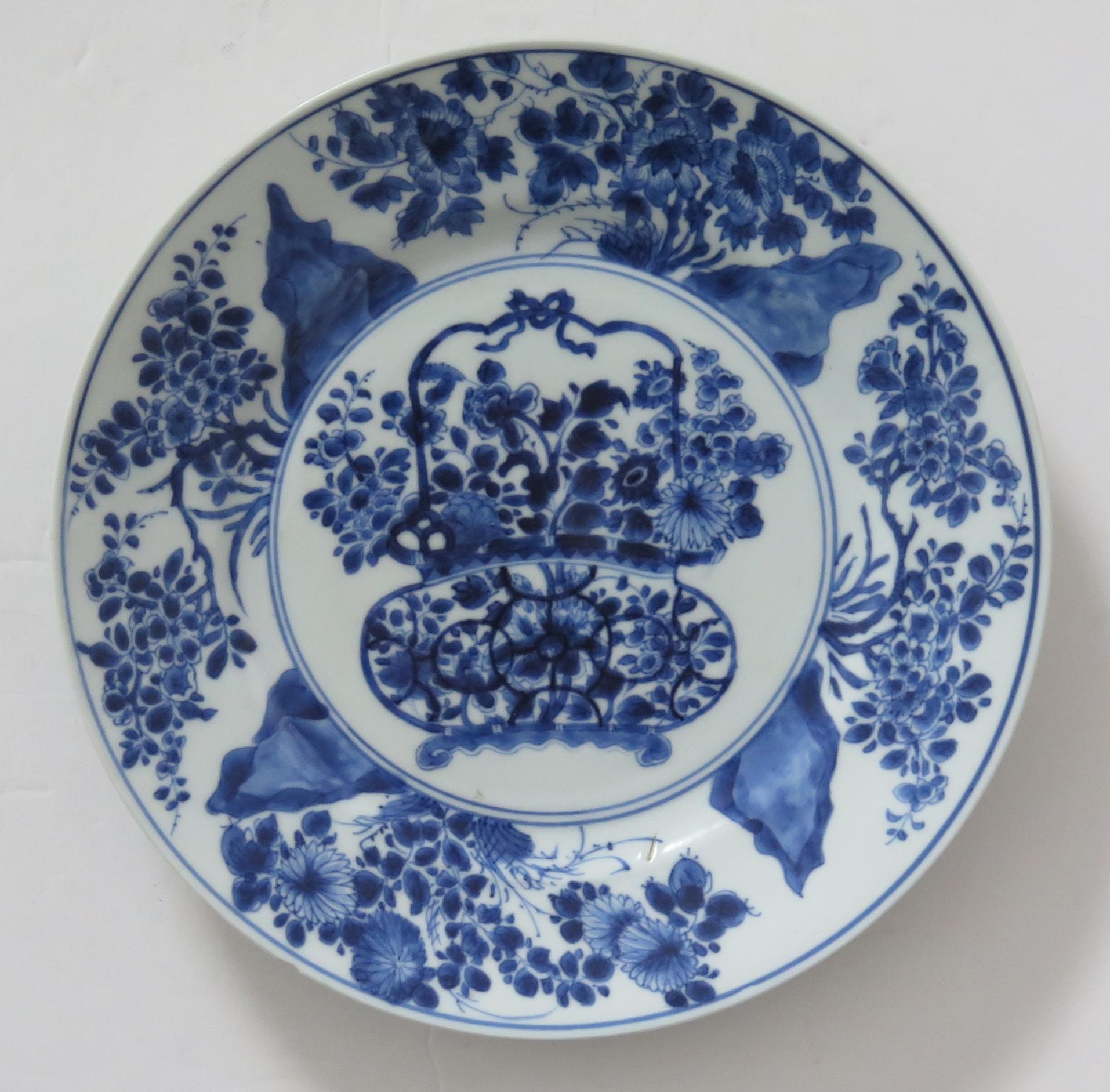 This is a beautifully hand-painted Chinese porcelain blue and white large plate from the Qing, Kangxi period, 1662-1722.

 It has a recognized mark for the period to the base.

The plate is finely potted with a carefully cut base rim and a lovely