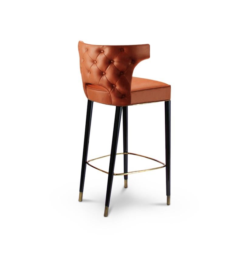 Each Spring, from 1866 to 1885, cowboys drove from Texas to railheads in Kansas. KANSAS Bar Chair is a tribute to their courage. This button-tufted back chair is upholstered in synthetic leather, and has glossy black lacquered legs, making it the