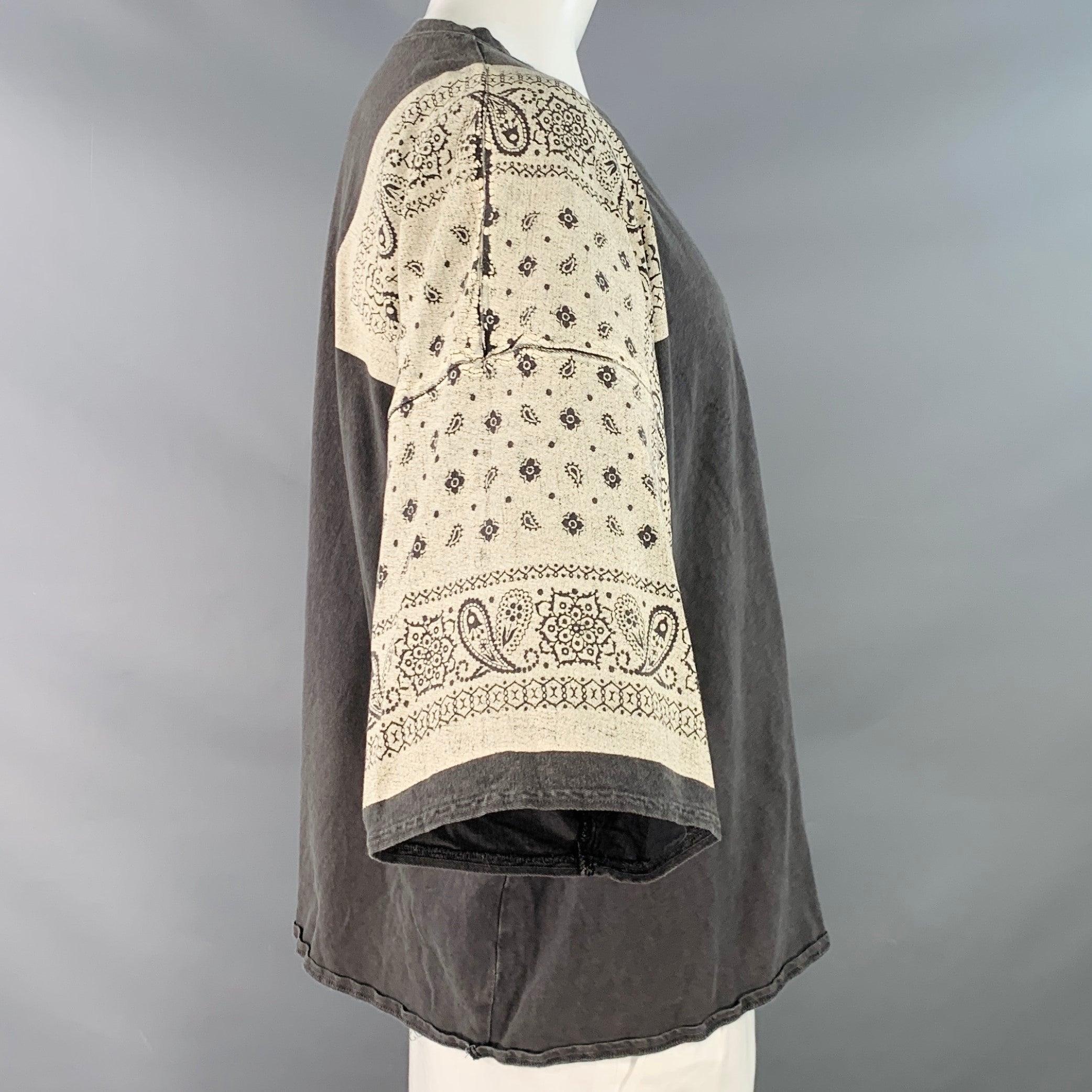 Camiseta KAPITAL
en jersey de algodón gris con hombros estampados de bandana crema, un bolsillo y corte oversize. Made in Japan. Muy buen estado de conservación. Señales de desgaste en los hombros, marcas en la parte delantera. 

Marcado:   JP 3