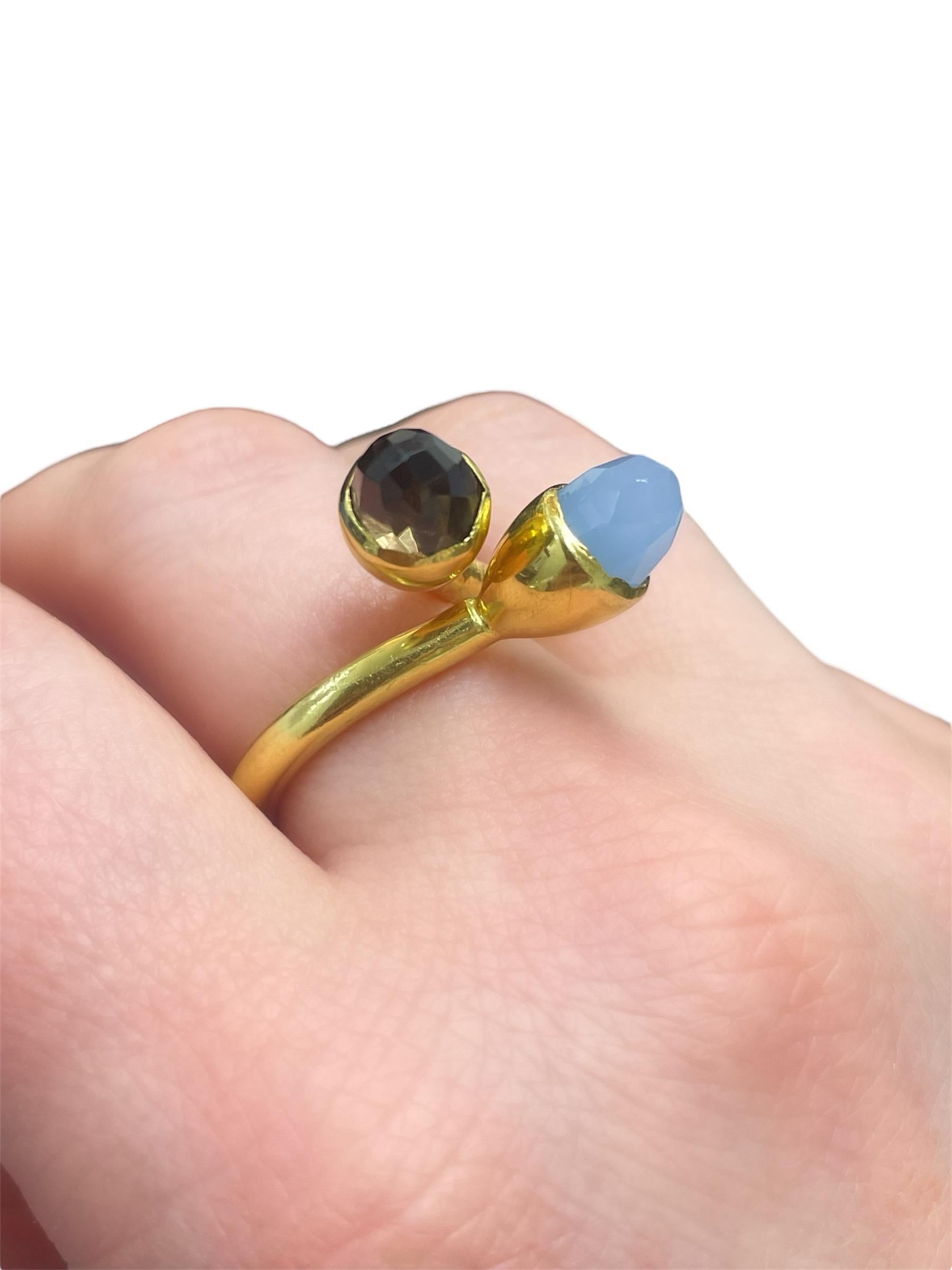 Cette magnifique bague bypass de la créatrice Kara Ross est ornée d'un quartz fumé et d'une calcédoine à facettes. Montée en or jaune 18 carats dans un design artisanal, cette bague ne manquera pas d'impressionner !

Tampon : KARA ROSS
Taille de