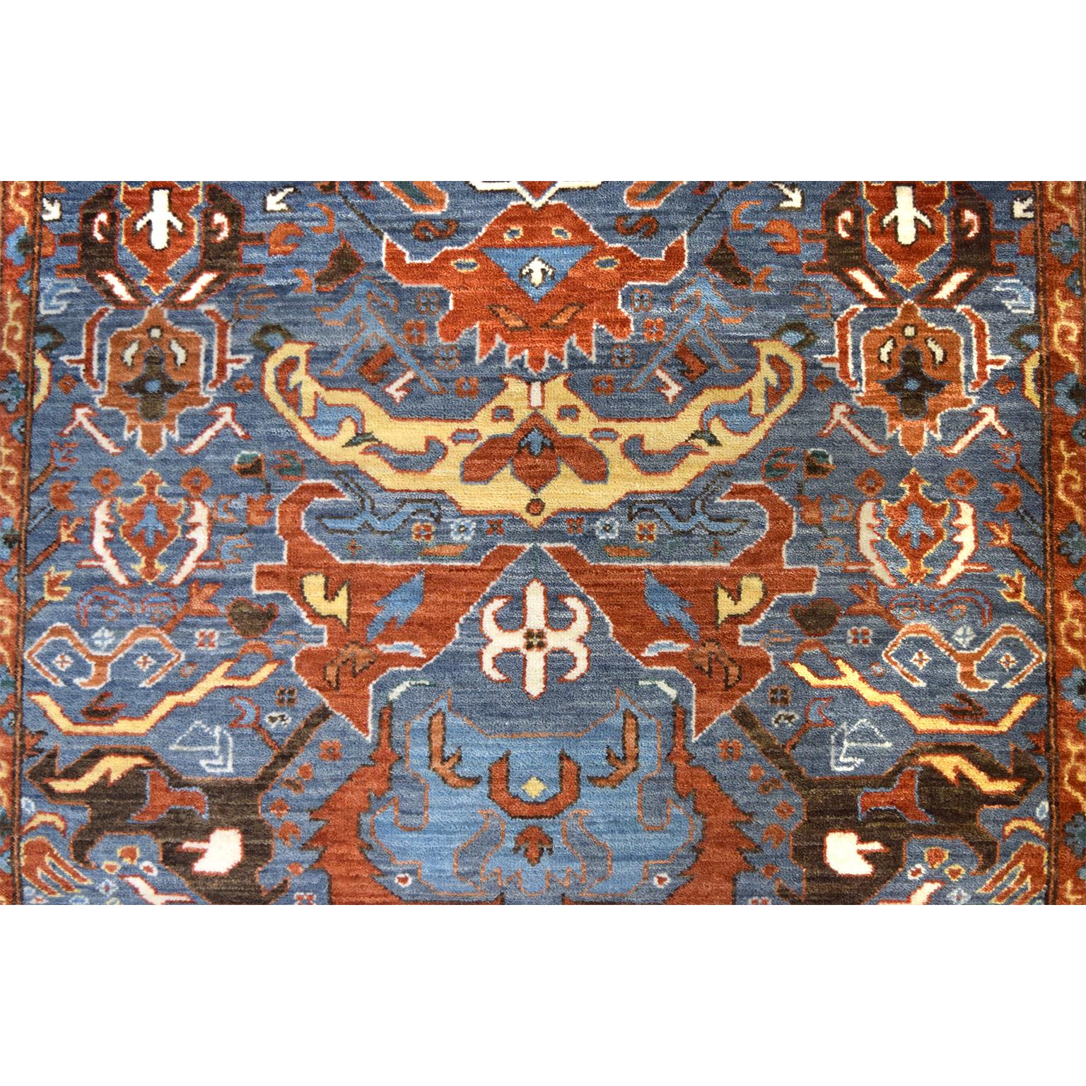 This Karabagh-inspired contemporary area rug in vibrant red and blue tones is part of the Orley Shabahang Tribal Revival collection and measures approximately 3’ x 5’. Like all Orley Shabahang carpets, this piece features handspun wool dyed with