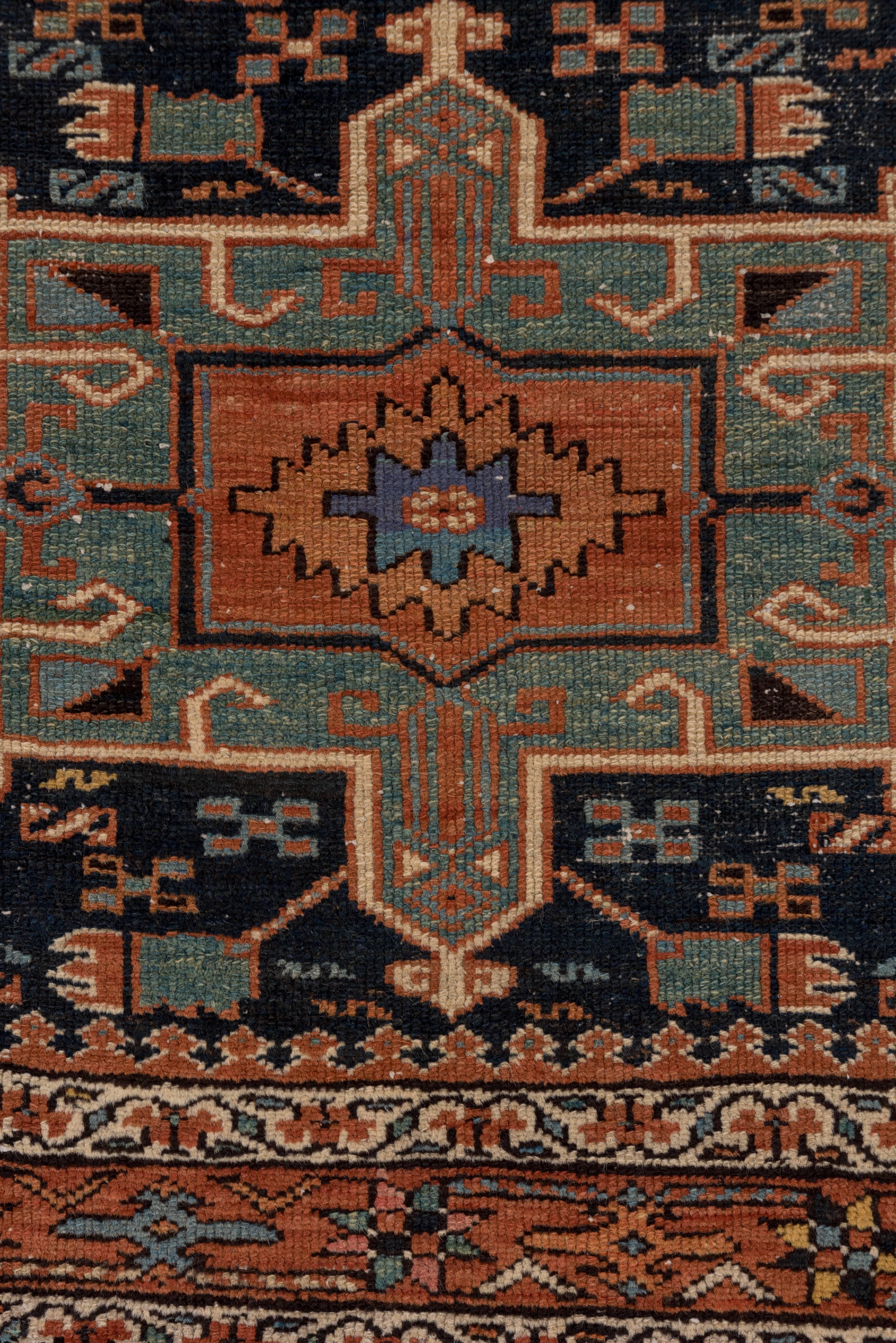 This attractive village rug was woven in the area of Karaja in the N.W. Iranian province of Azerbaijan, close to the better known town of Heriz . The typically hooked medallion and boxed rectangular medallions flanking it appear to float on the deep