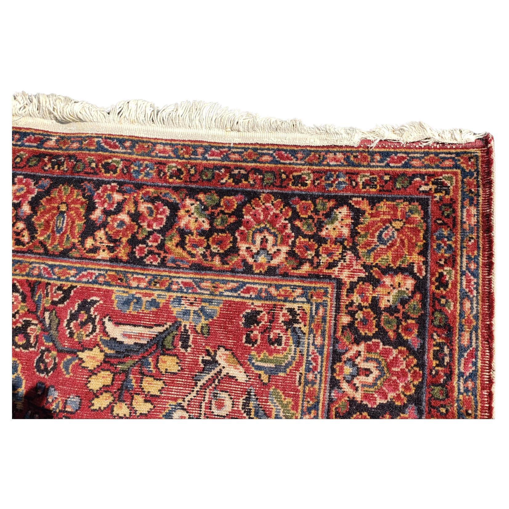 An outstanding early 20th century Sarouk rug with a traditional all-over floral pattern woven in rich indigos, cranberries, and darks colors, and surrounded by one of the best floral pattern borders we've seen in a long time! Measures 9' x 6.'