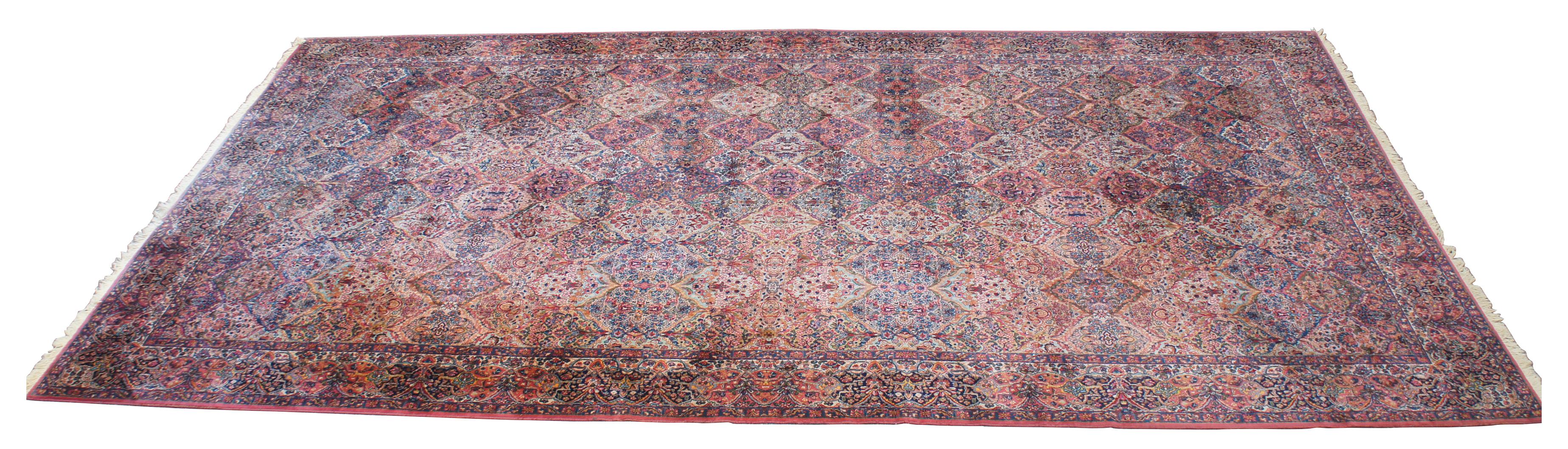 Vintage early Karastan Kirman 717 multi-color panel area rug. Features a geometric and floral motif over a field of reds, with blues, orange, brown, pinks, gold, greens and purples. Measure: 22'.
   