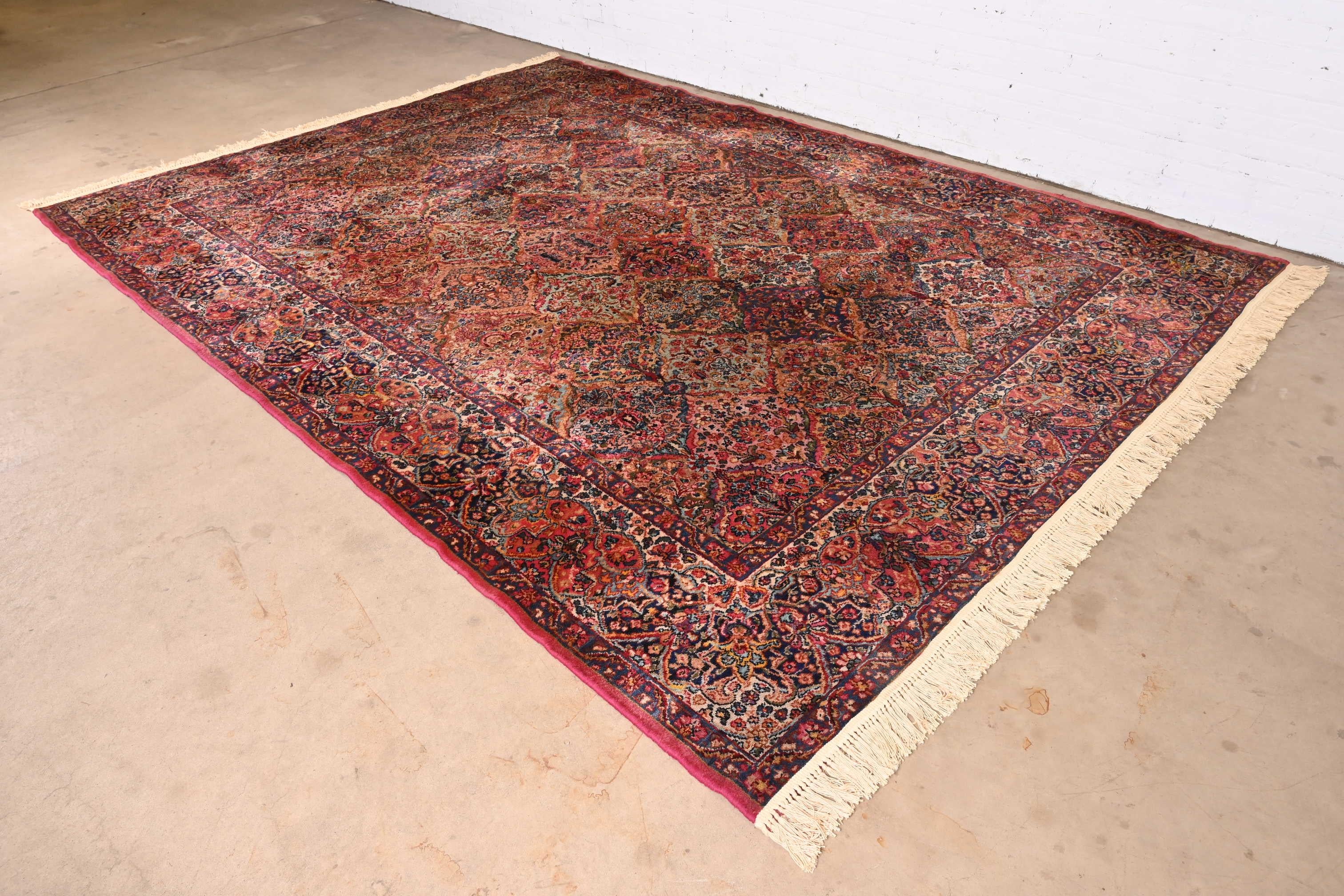 An exceptional Persian Kirman style room size rug

By Karastan

USA, Circa 1940s

Features a beautiful all-over patchwork pattern containing myriad flowers woven in myriad colors across the field, and surrounded by a border of similar pattern