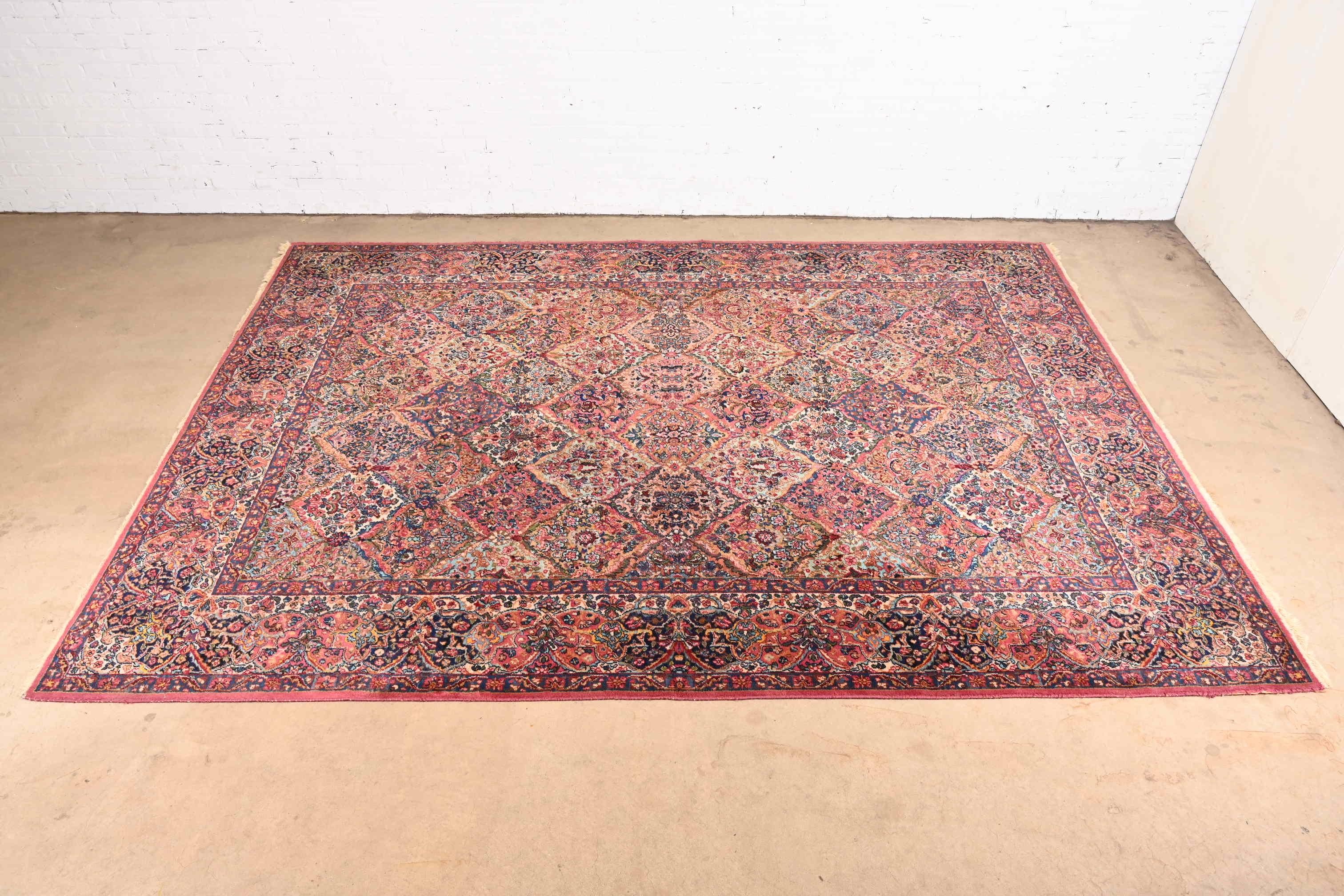 A gorgeous Persian Kirman style room size rug

By Karastan

USA, circa 1940s

Features a beautiful all-over patchwork pattern containing myriad flowers woven in myriad colors across the field, and surrounded by a border of similar pattern and