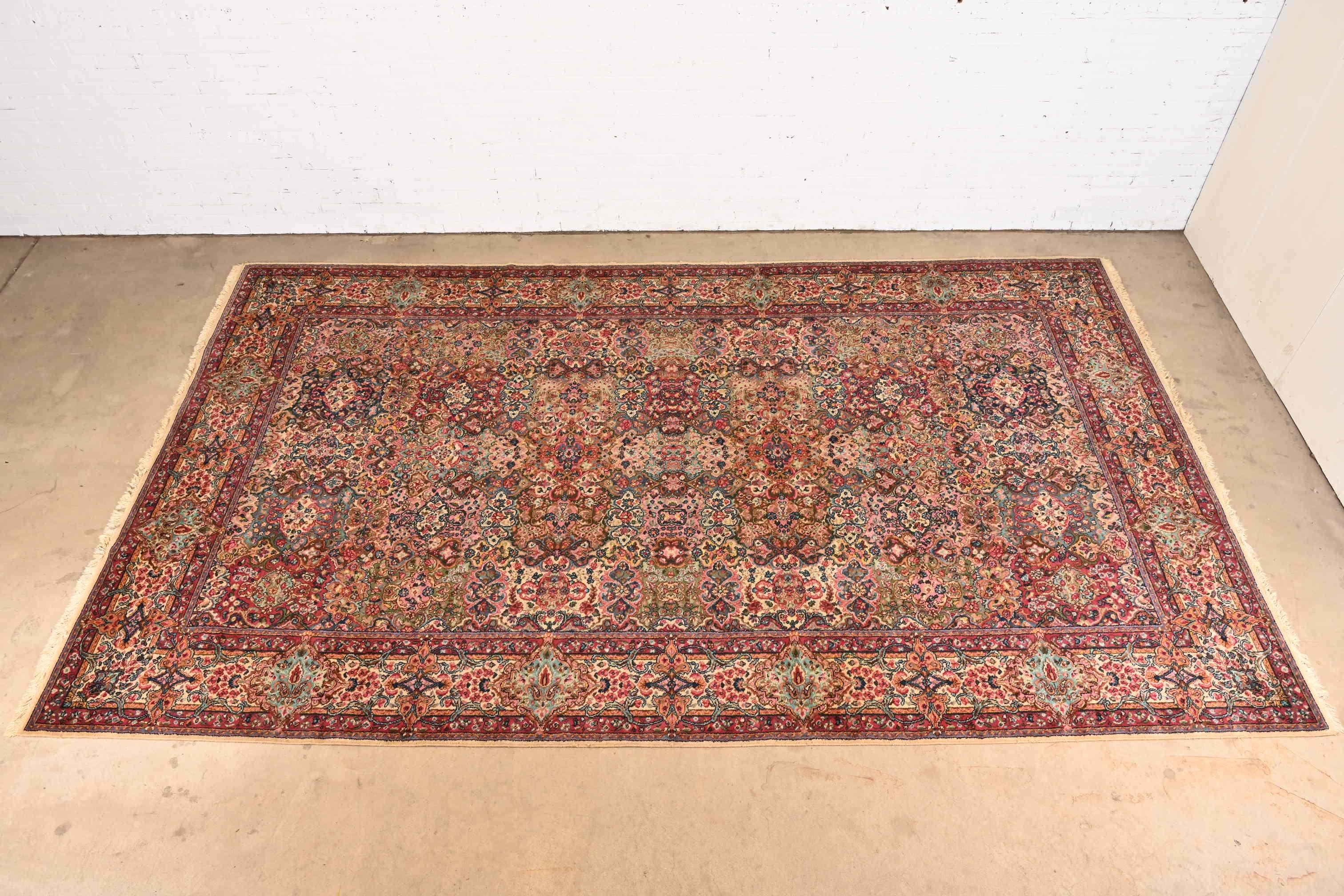 An exceptional Persian Kirman style room size wool rug

By Karastan

USA, Circa 1940s

Features a beautiful all-over patchwork pattern containing myriad flowers woven in myriad colors across the field, and surrounded by a border of similar pattern
