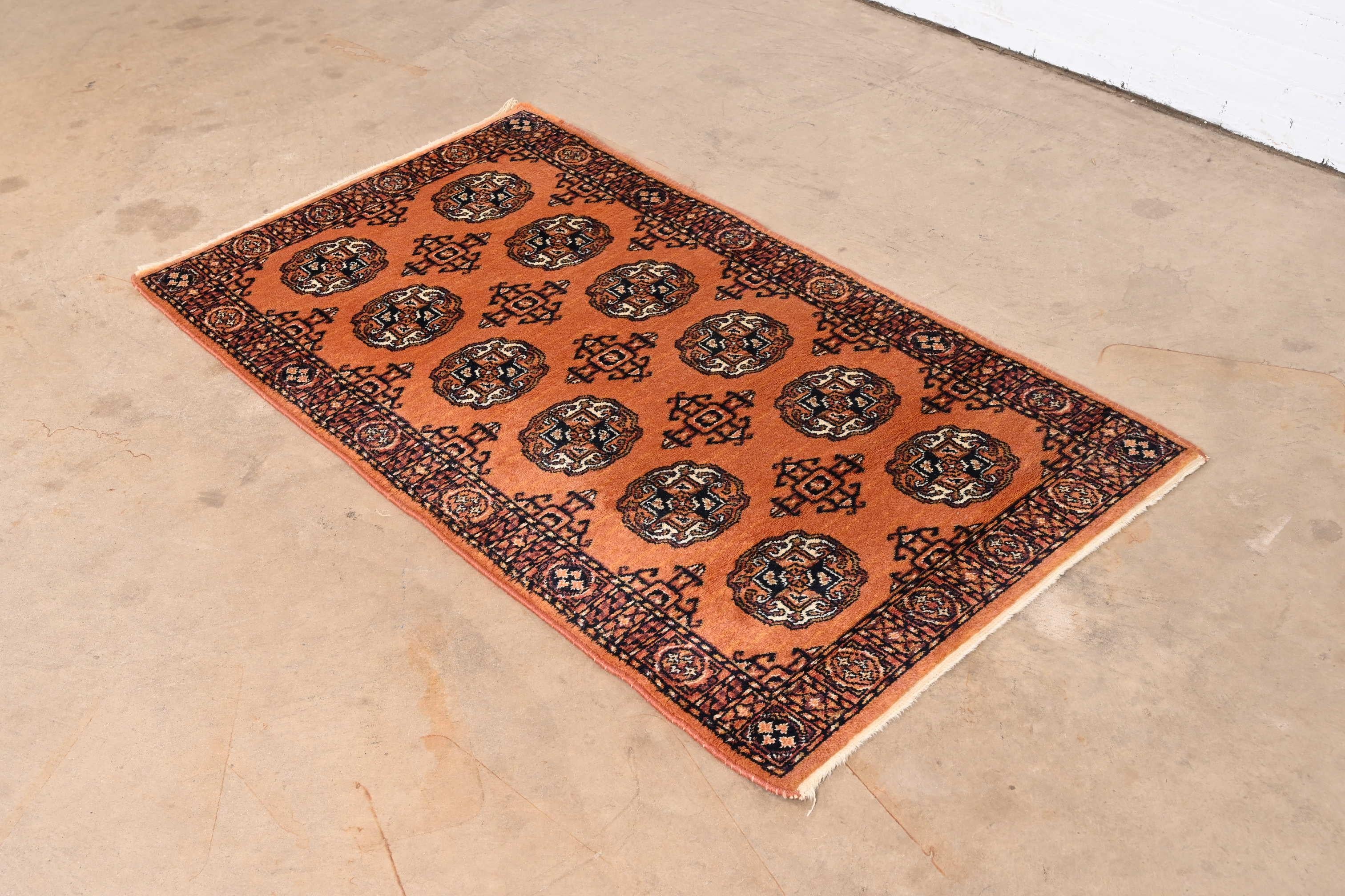 A gorgeous Persian Bokhara style wool rug

By Karastan

USA, Mid-20th century

Beautiful geometric design, with predominant colors in orange, brown, black, and ivory.

Measures: 34