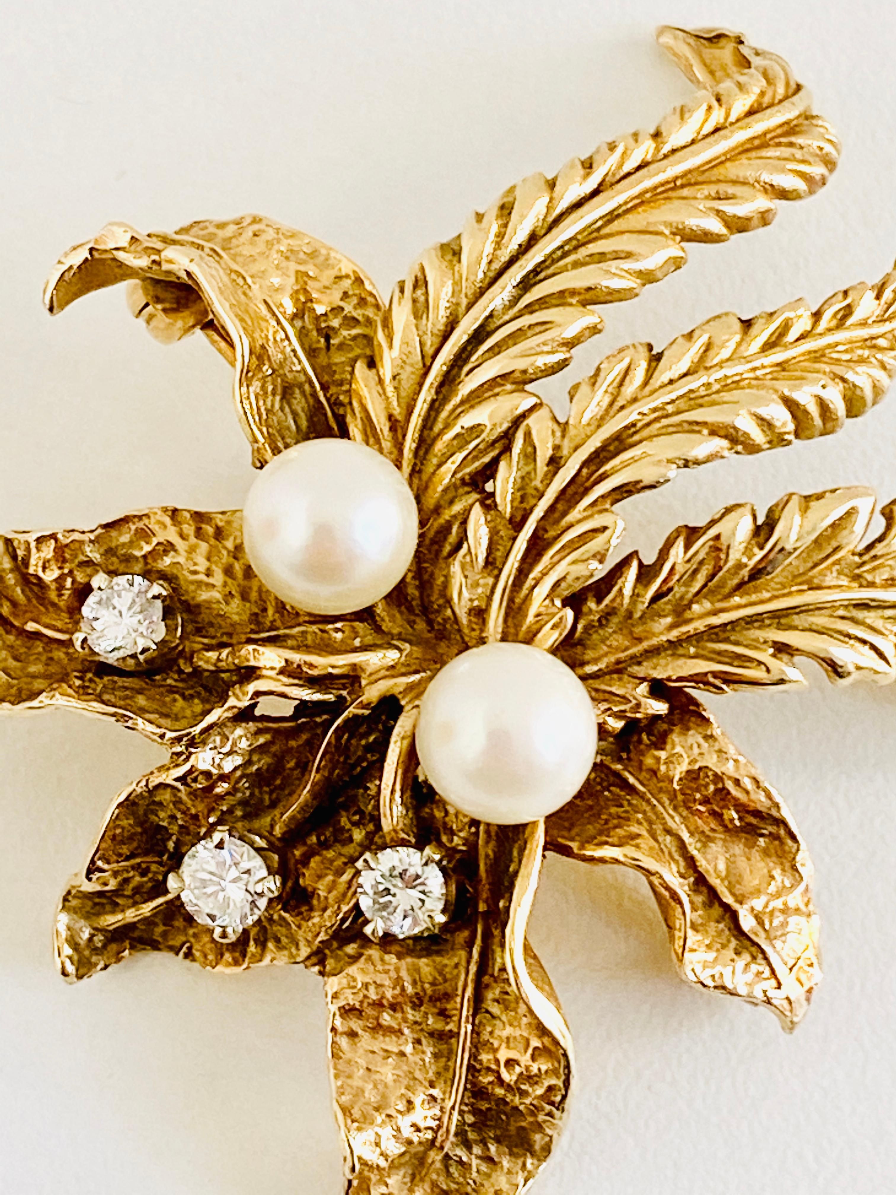 Elegant brooch from the 1960's featuring 3 round brilliant cut diamonds, approximately .34ct total weight and 2 beautiful cultured pearls. Set in 14k yellow gold. 

Size: 1-7/8” tall X 1-1/2