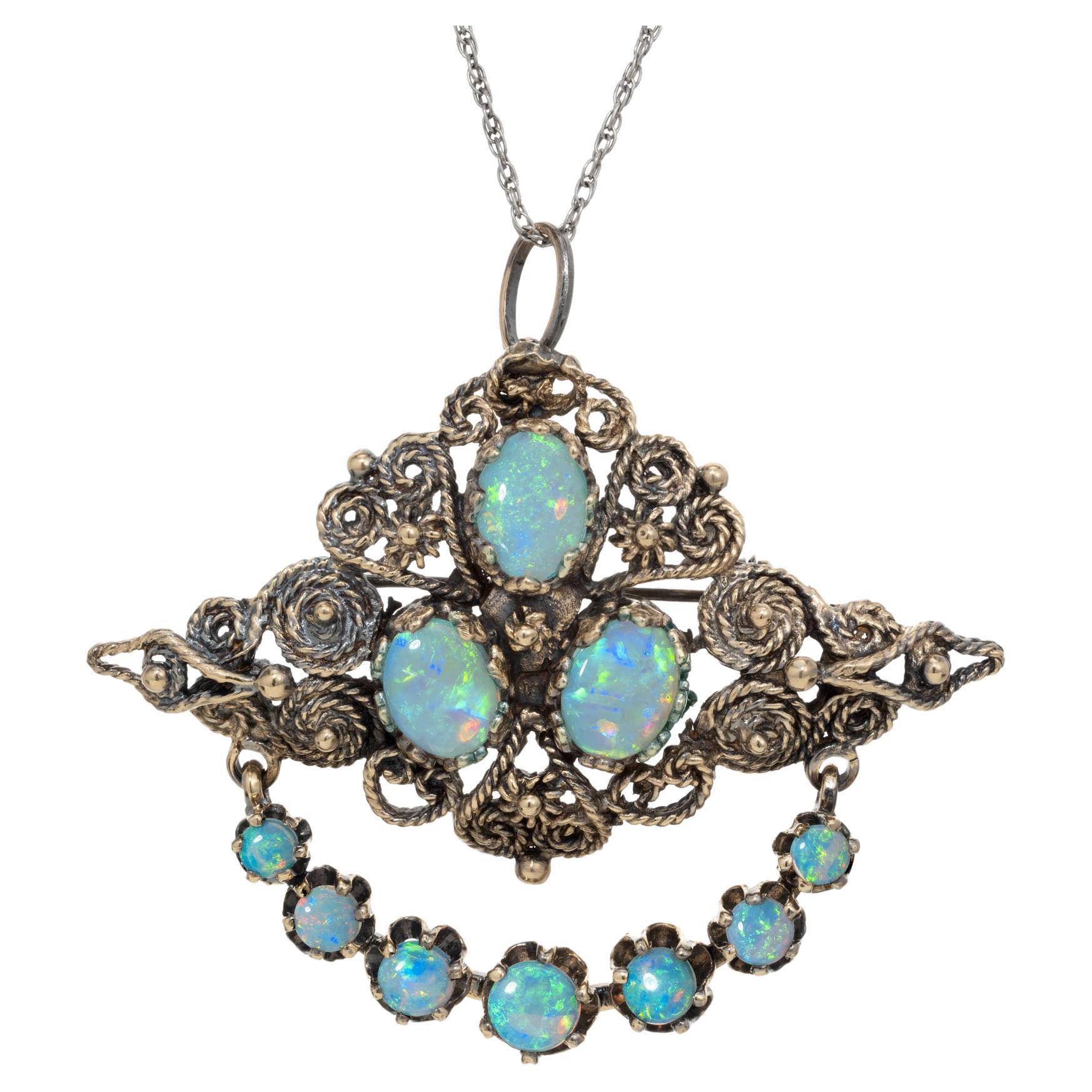 Exceptional Karbra fine opal brooch pendant necklace. Antique revival style made in the 1960's by Karbra. 3 oval opals are mounted in the center of the 14k yellow gold pendant accented with a dangle bar of 7 graduated round opals. This unique highly
