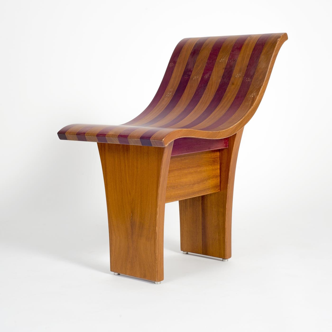 The linear forms of this modern chair merge functional style with comfort for a unique sitting experience. Framed in solid wood, the wide seat and contoured low back boast iroko and purple woods, the colors recalling vintage drapes. The chair stands