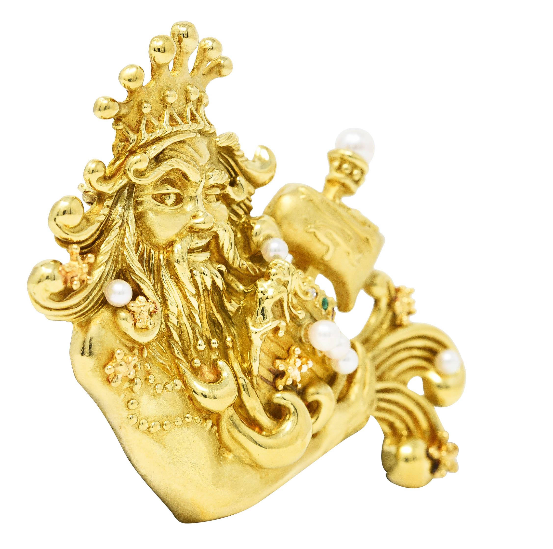 Designed as a highly rendered Poseidon wearing a crown and holding a ship among the waves
Grooved with texturous hair and gold beaded detailing - boat sails feature dragon motif. Accented by a round cut diamond, emerald, ruby, and sapphire on ship.