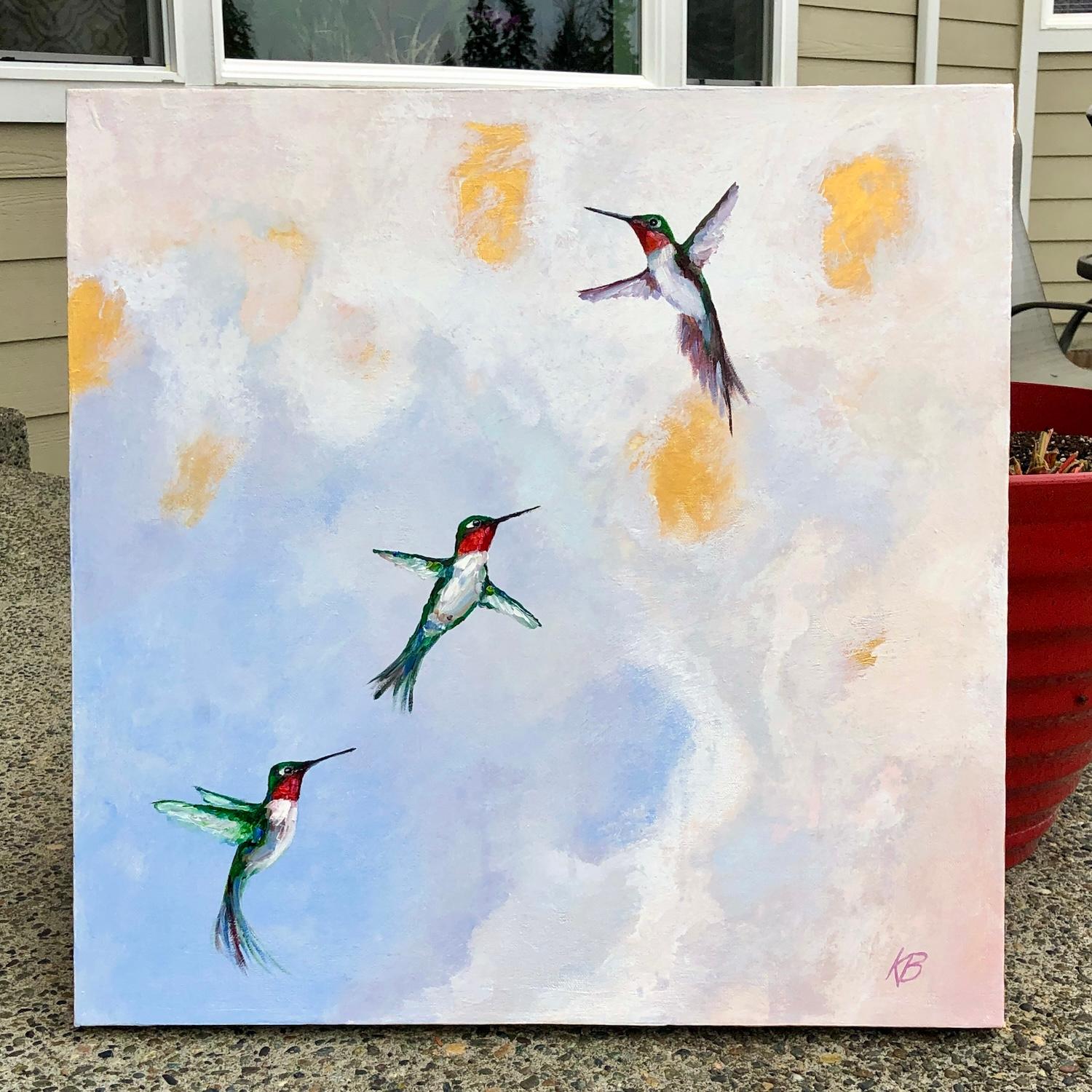 <p>Comentarios del artista<br />Tres colibríes se elevan graciosamente contra un cielo suave y soñador lleno de nubes pastel y luz dorada. Sus formas delicadas y sus cuerpos de tonos joya destacan sobre el sereno telón de fondo. Esta escena se