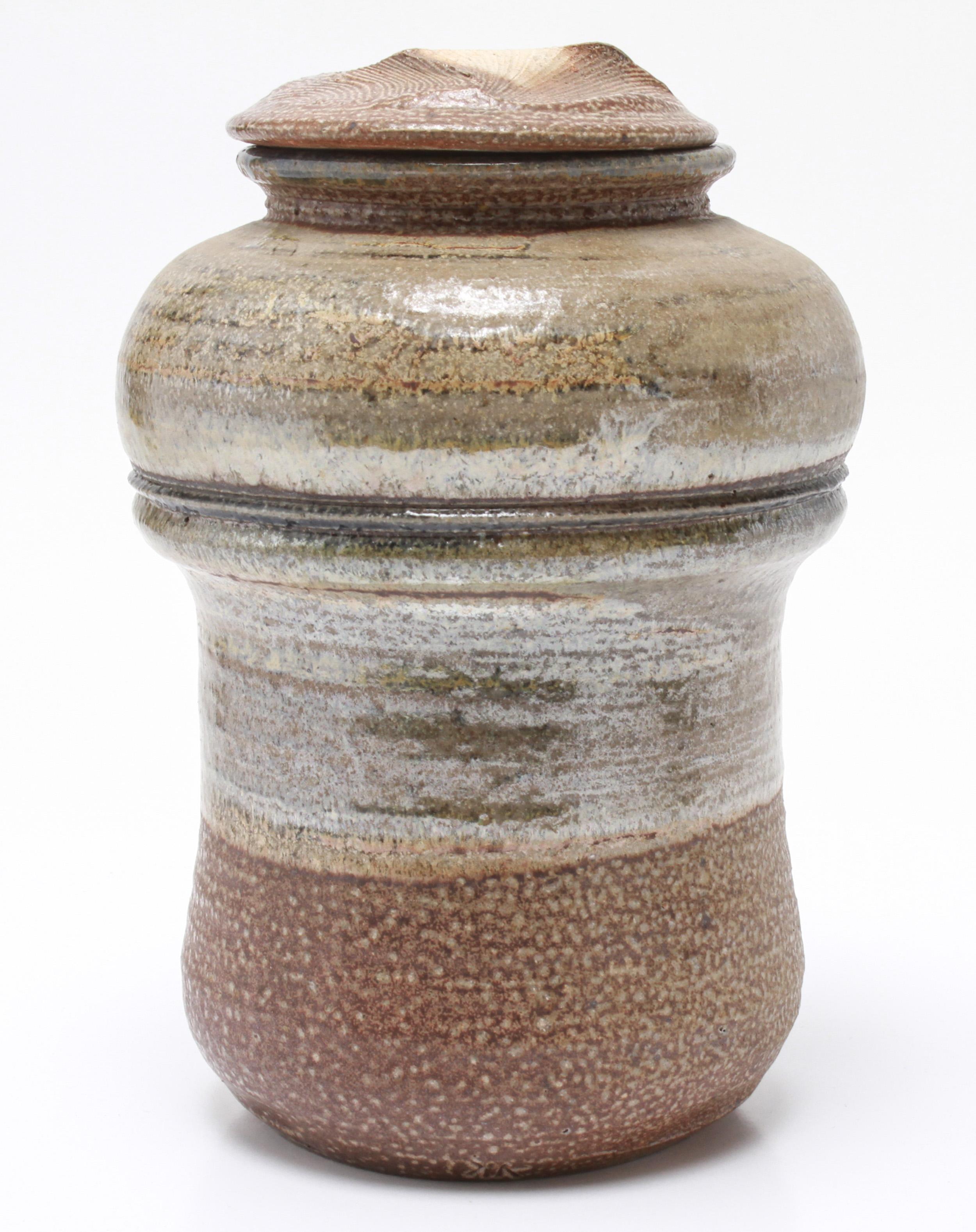 American Mid-Century Modern stoneware art pottery covered jar designed by Karen Karnes (American, 1925-2016) with a grey-green and blue glaze. The piece is signed with an impressed artist's monogram 