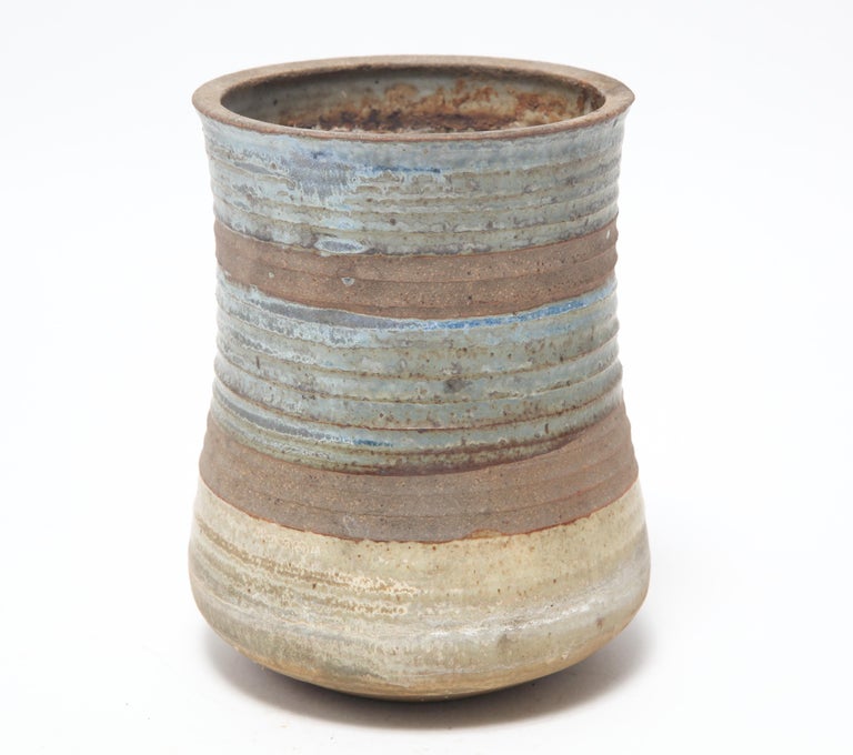 American Mid-Century Modern stoneware art pottery vase or planter designed by Karen Karnes (American, 1925-2016) with turquoise, blue, and brown glazes in alternating horizontal bands. The piece is signed with an impressed artist's monogram 