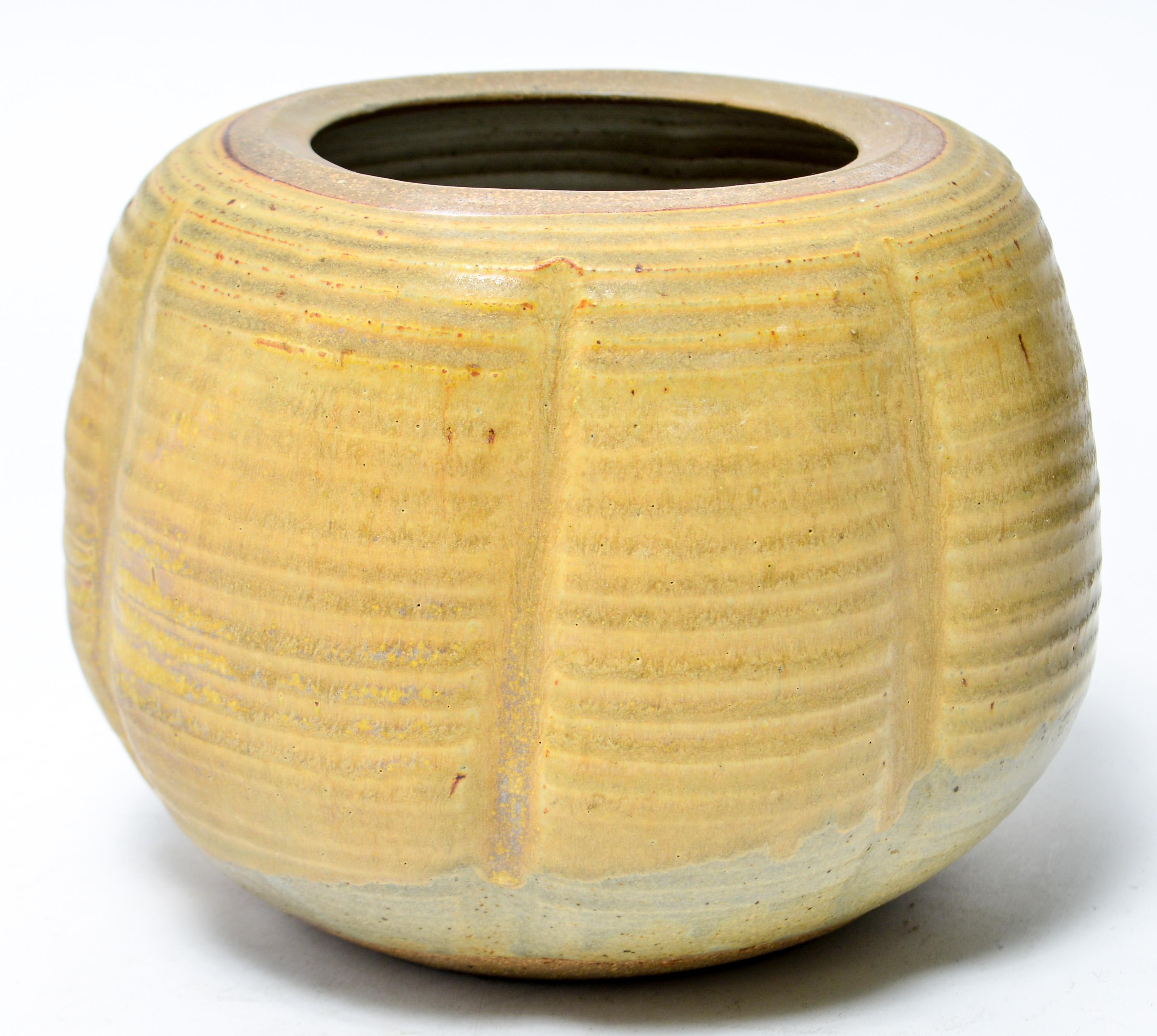 American Mid-Century Modern stoneware art pottery vase designed by Karen Karnes (American, 1925-2016) with body in lobed form and green glaze. The piece is signed with an impressed artist's monogram 