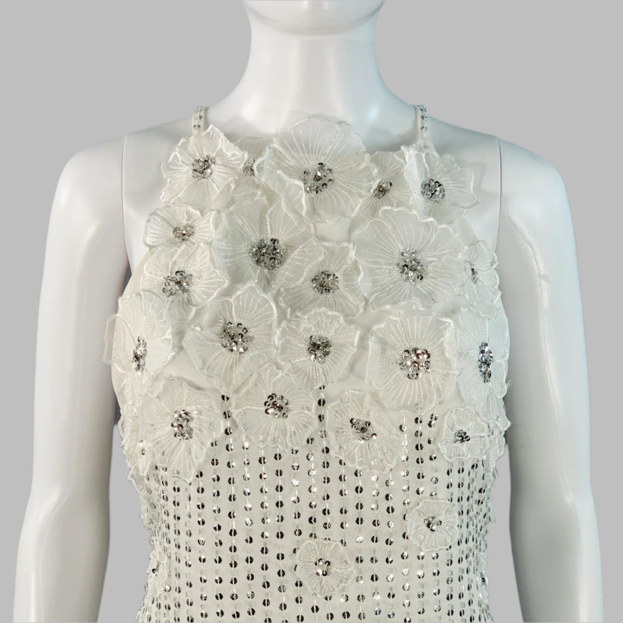 Abito da sera Karen Millen
in tessuto bianco con un design di paillettes e perline color argento con applicazioni floreali di perline, spalline e chiusura con cerniera laterale. 

Contrassegnato:   UE 36 

Misure: 
  Busto: 32 pollici Vita: 26