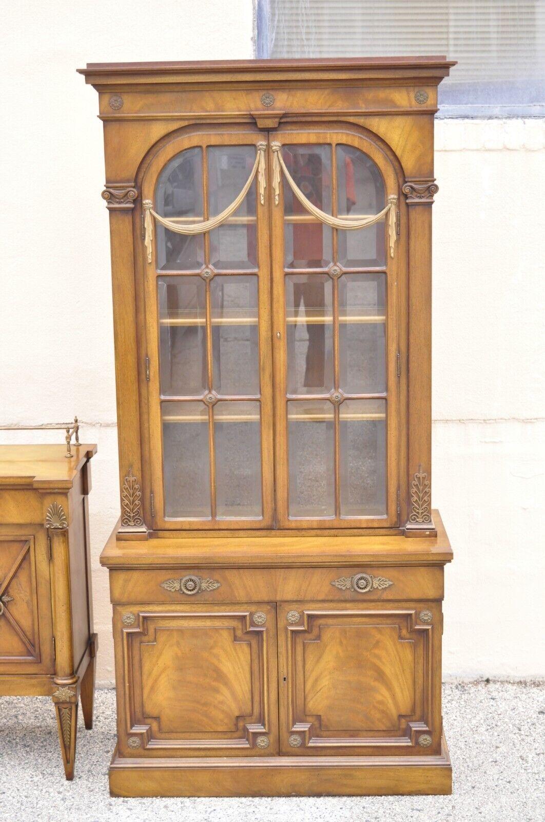 Karges French Neoclassical style Regency mahogany Curio China cabinet - a Pair. Item features cast brass ormolu, beveled glass, carved wood drape accents, pull out desk surface with tooled leather top and additional storage, 4 swing doors, working