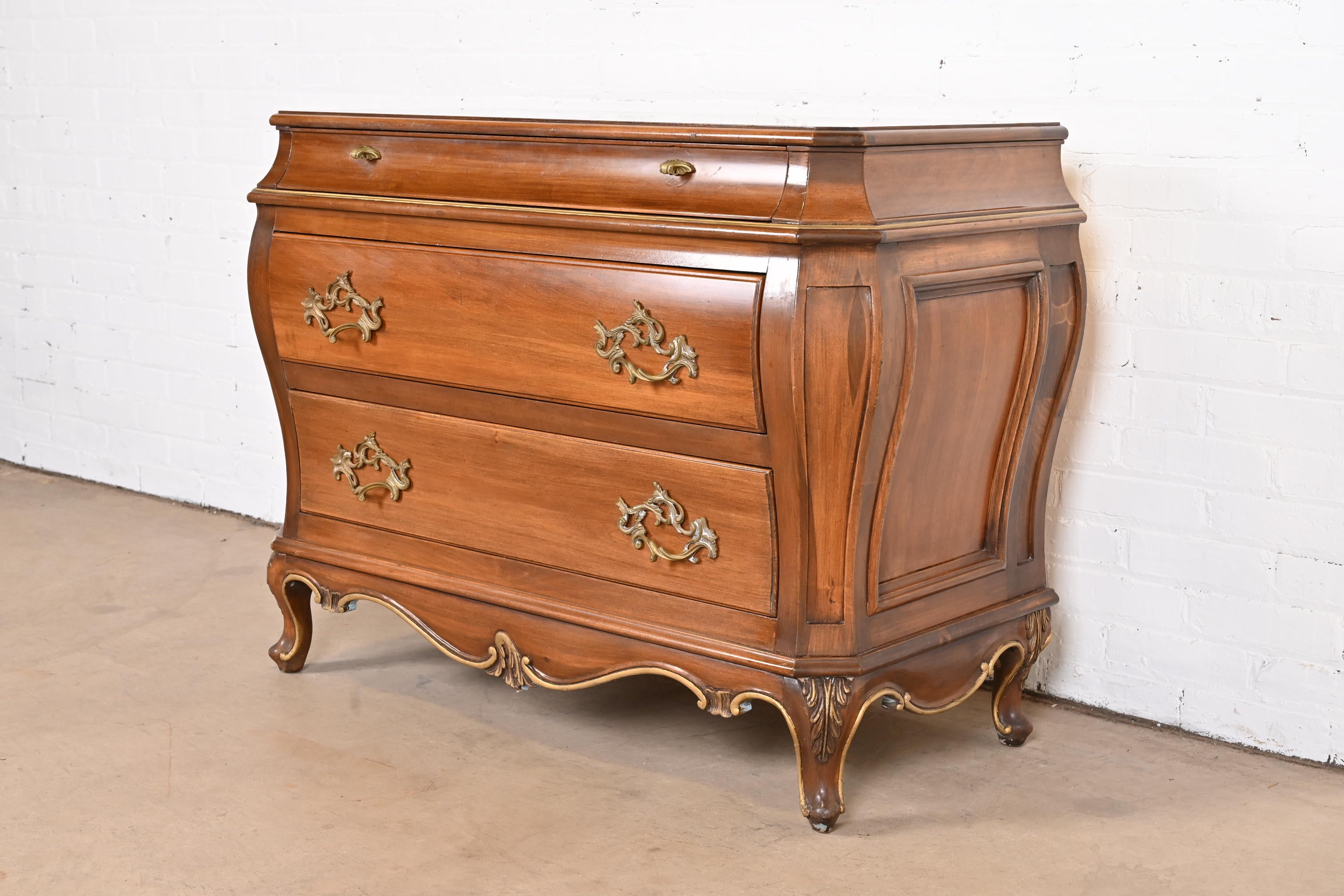 A beautiful French Provincial Louis XV style bombay chest of drawers or commode

By Karges Furniture

USA, Late 20th Century

Carved walnut, with gold gilt details and original brass hardware.

Measures: 43
