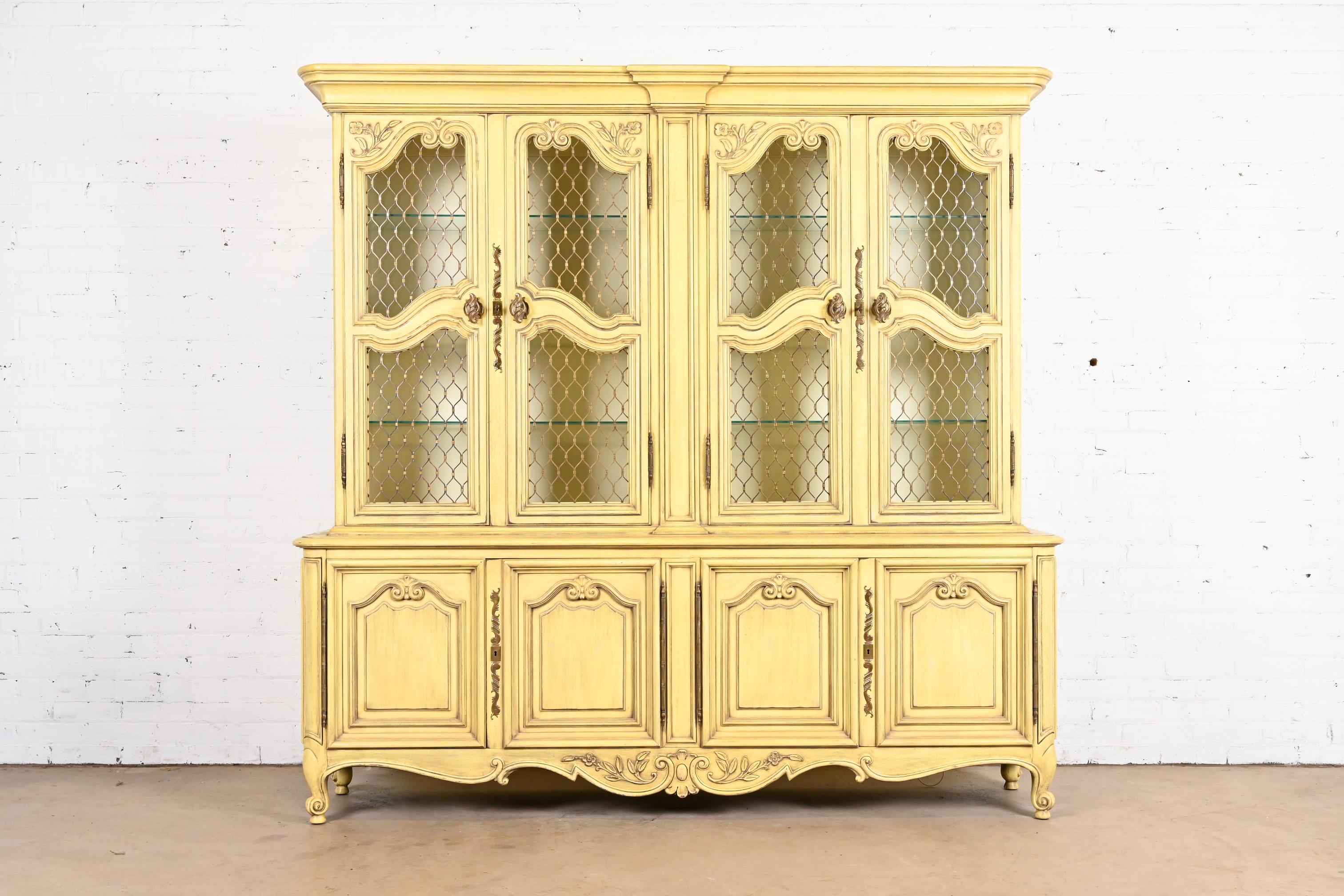 A beautiful French Provincial Louis XV style lighted breakfront bookcase or dining cabinet

By Karges

USA, Circa 1960s

Carved cream lacquered walnut, with original brass hardware. Cabinet locks, and key is included.

Measures: 80.25