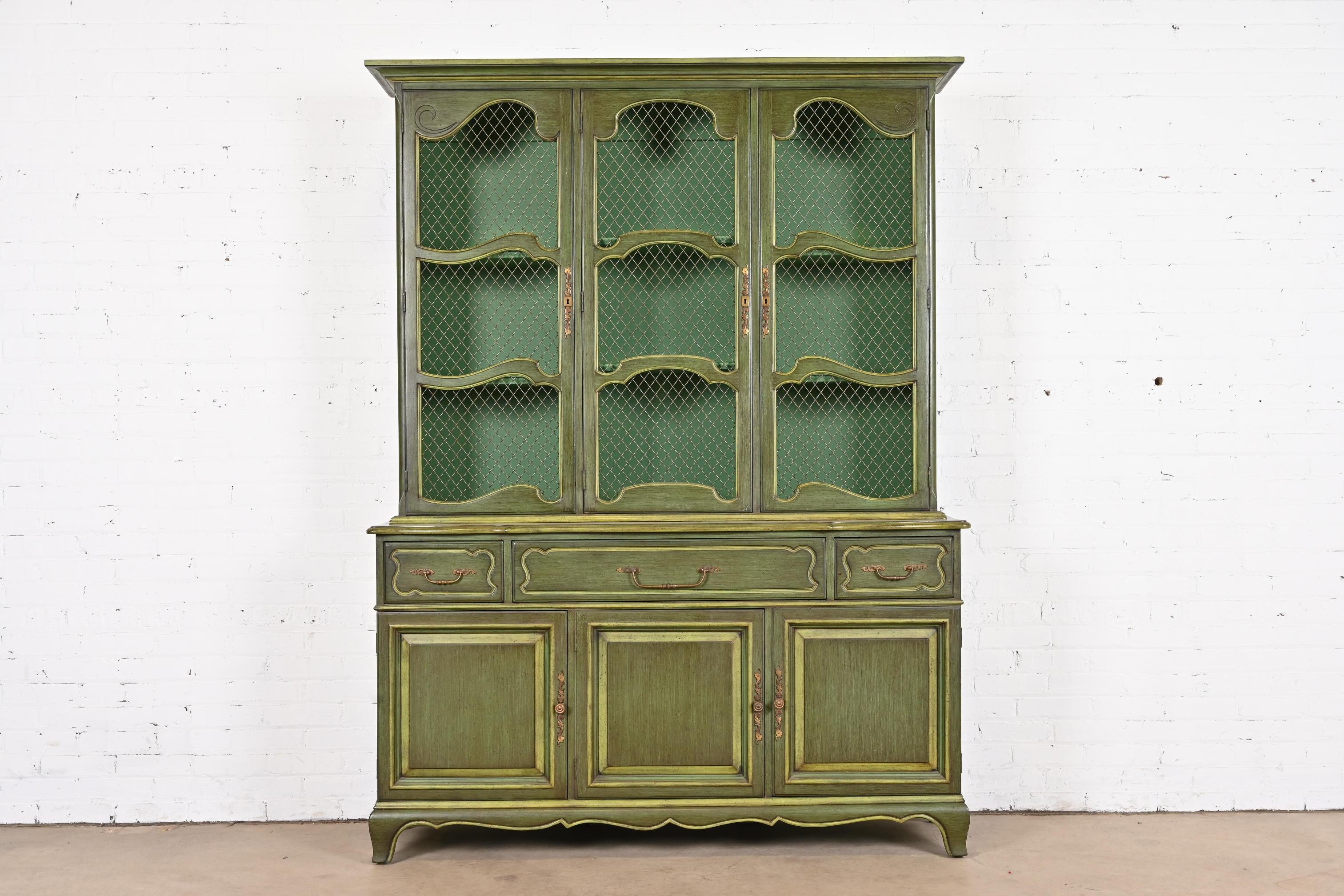 A beautiful French Provincial Louis XV style breakfront bookcase or dining cabinet

By Karges

USA, circa 1960s

Carved green lacquered walnut, with original brass hardware.

Measures: 60.5