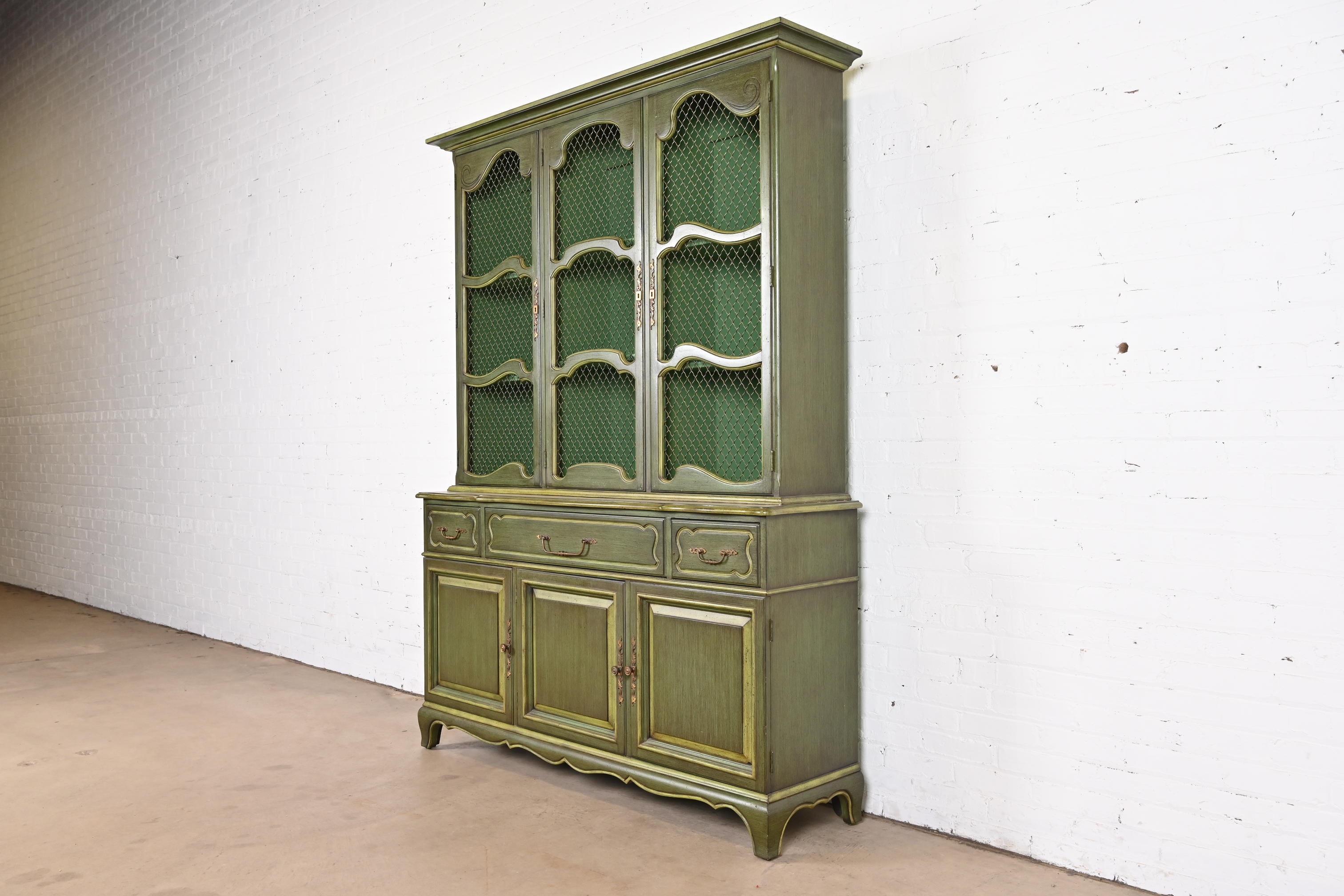 A beautiful French Provincial Louis XV style breakfront bookcase or dining cabinet

By Karges

USA, circa 1960s

Carved green lacquered walnut, with original brass hardware.

Measures: 60.5