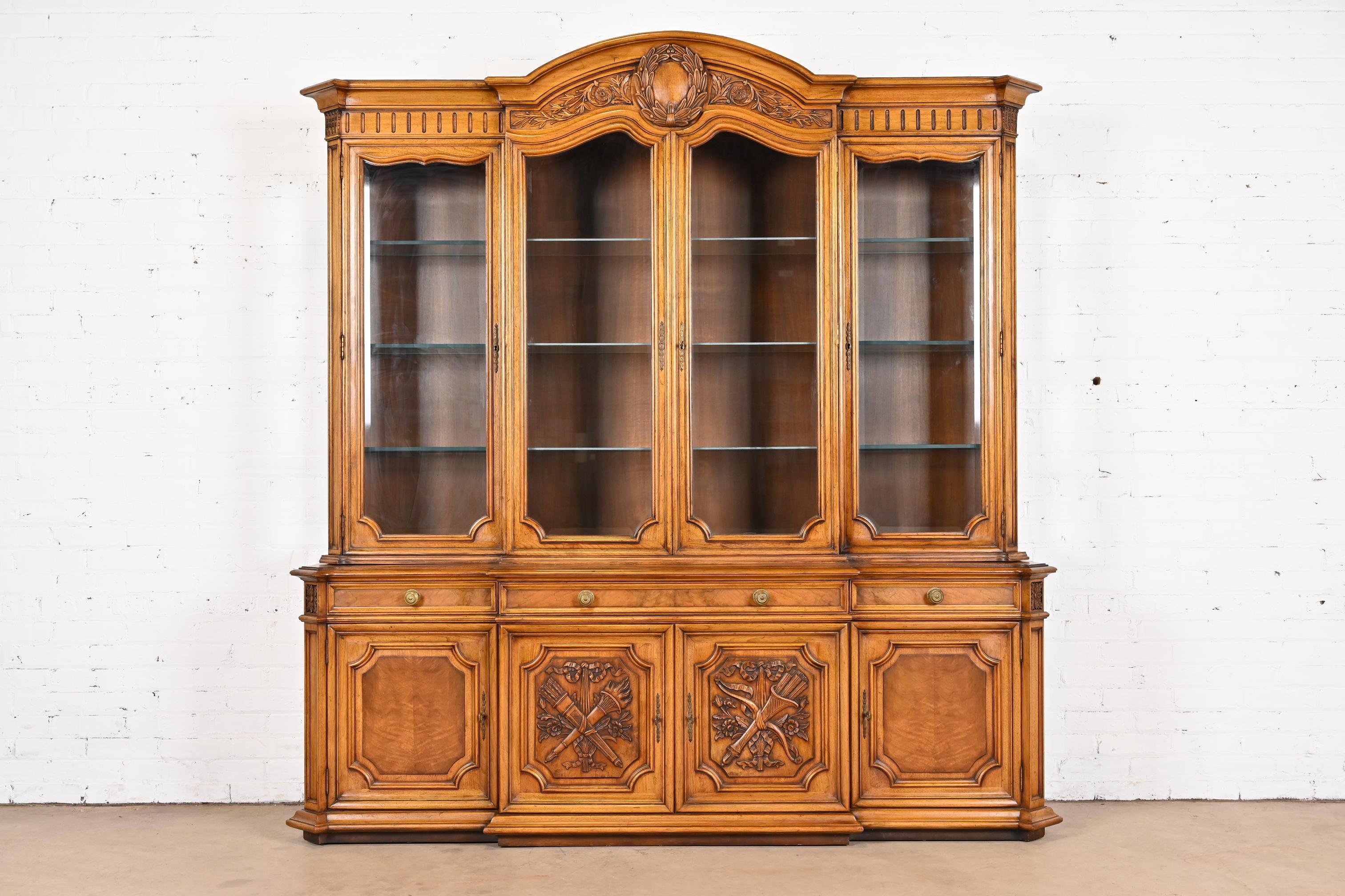 A gorgeous French Regency Louis XVI style lighted breakfront bookcase or dining cabinet

By Karges

USA, Circa 1960s

Carved burled walnut, with glass front doors and original brass hardware. Cabinet locks, and key is included.

Measures: 80.25