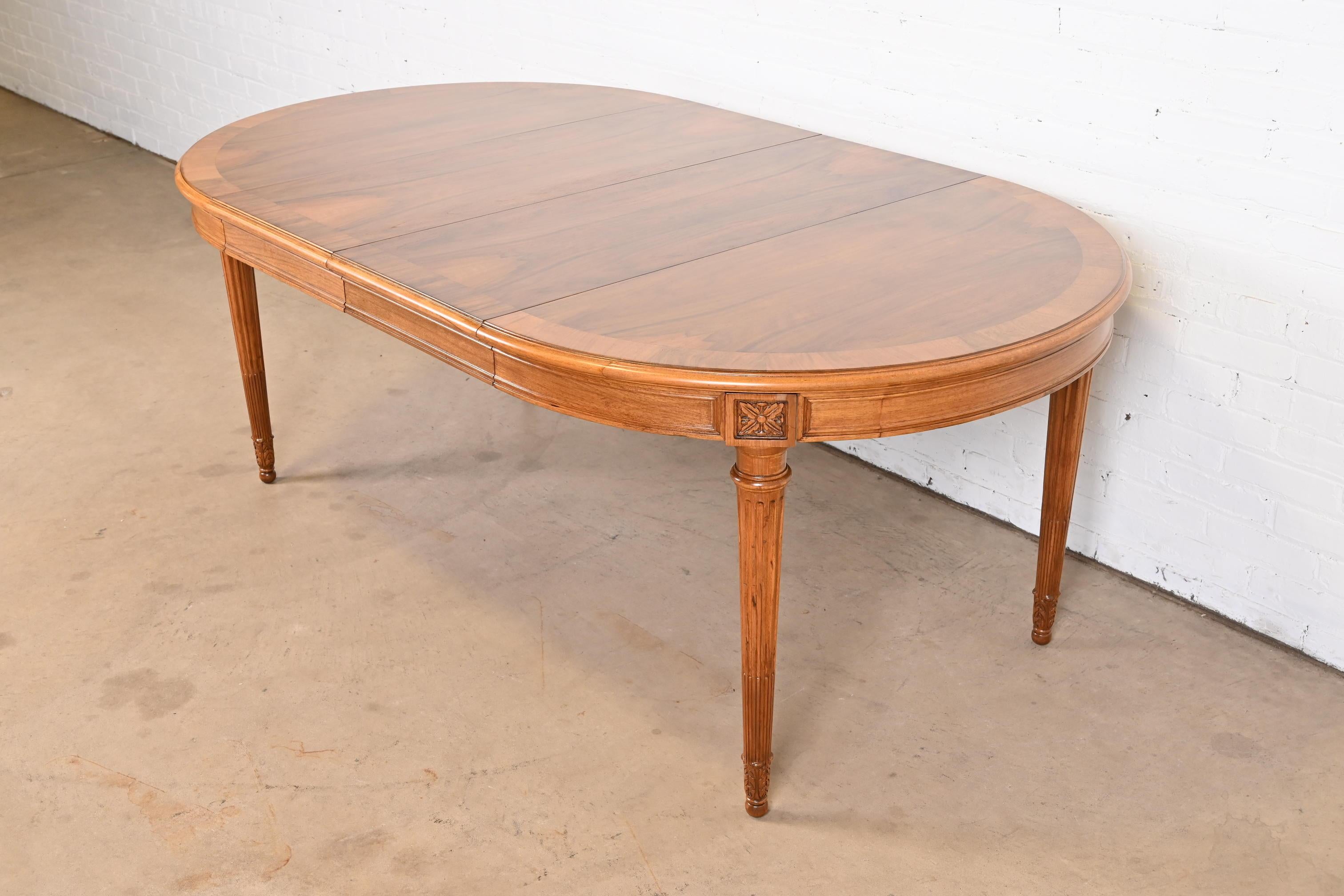 An exceptional French Regency Louis XVI style extension dining table

By Karges Furniture

USA, Circa 1960s

Book-matched banded burled walnut top, with carved solid walnut apron and legs.

Measures: 44