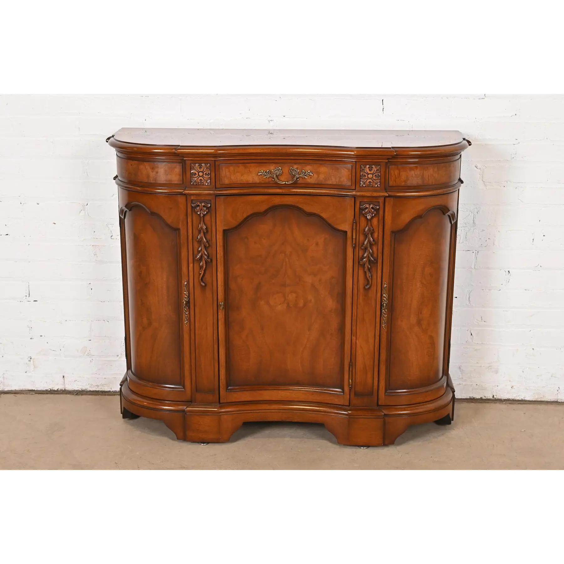 A gorgeous French Regency Louis XVI style sideboard buffet, bar cabinet, or commode

By Karges

USA, Circa 1980s

Carved burled walnut, with original brass hardware.

Measures: 43