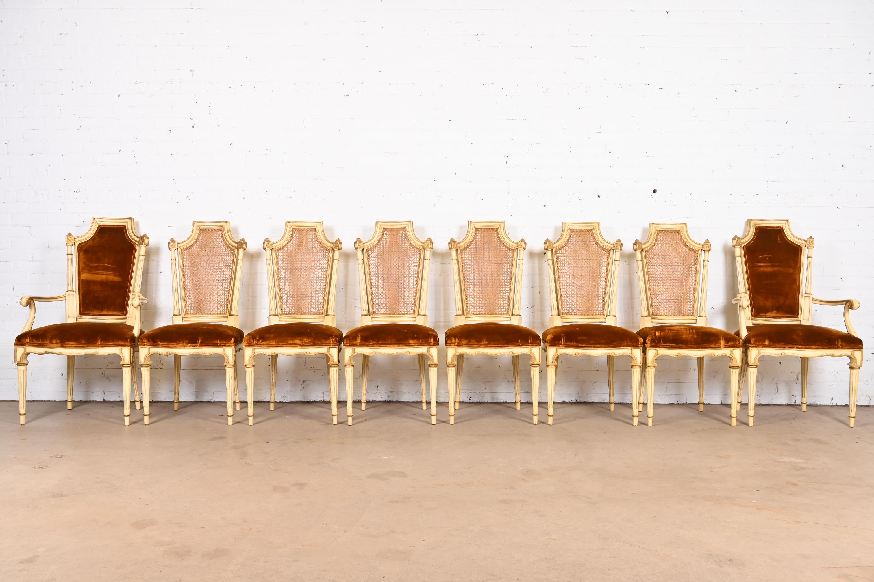 An outstanding set of eight French Regency Louis XVI style dining chairs

By Karges Furniture

USA, Circa 1960s

Gorgeous carved cream painted walnut frames, with gold gilt details, caned backs, and velvet upholstered seats.

Measures: 
Side chairs: