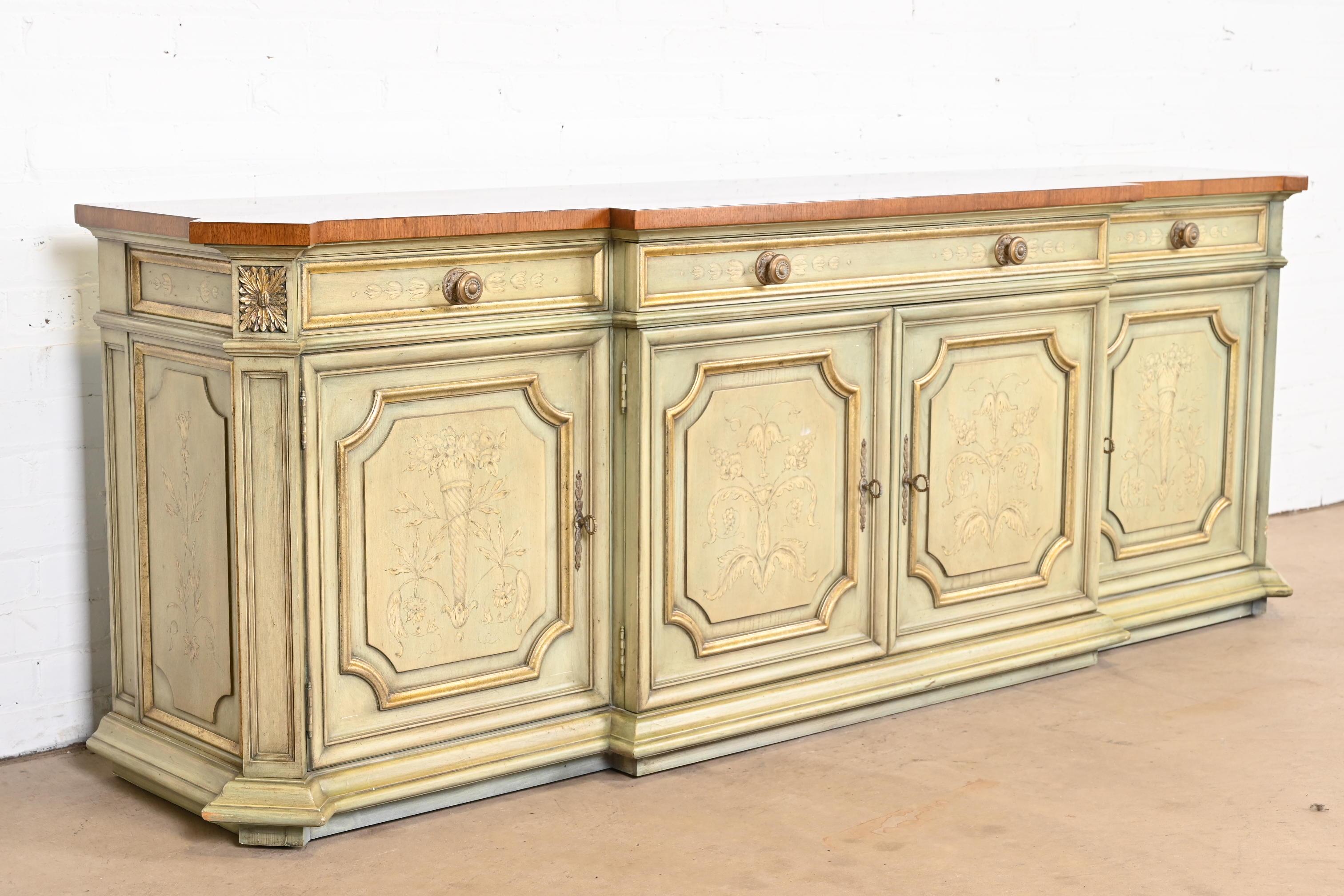 A beautiful Neoclassical or French Regency Louis XVI style breakfront sideboard, credenza, or bar cabinet

By Karges Furniture

USA, Circa 1960s

Carved hand painted walnut, with gold gilt details, beautiful book-matched burled walnut top, and