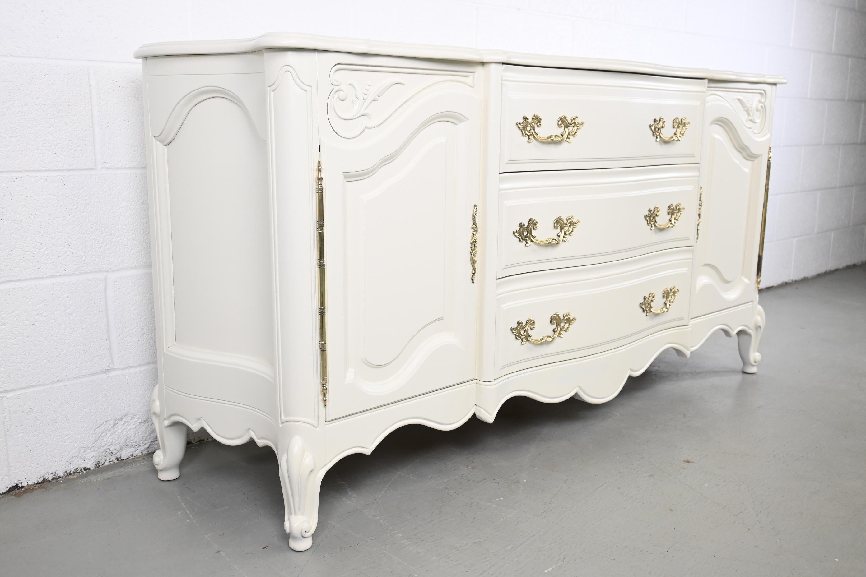 Karges Furniture Louis XV Style French Provincial Ivory Credenza or Sideboard

Karges Furniture, USA, 1980s

Measures: 66.5 Wide x 18.75 Deep x 32.88 High

Louis XV Style French Provincial ivory lacquered credenza with carved details and brass