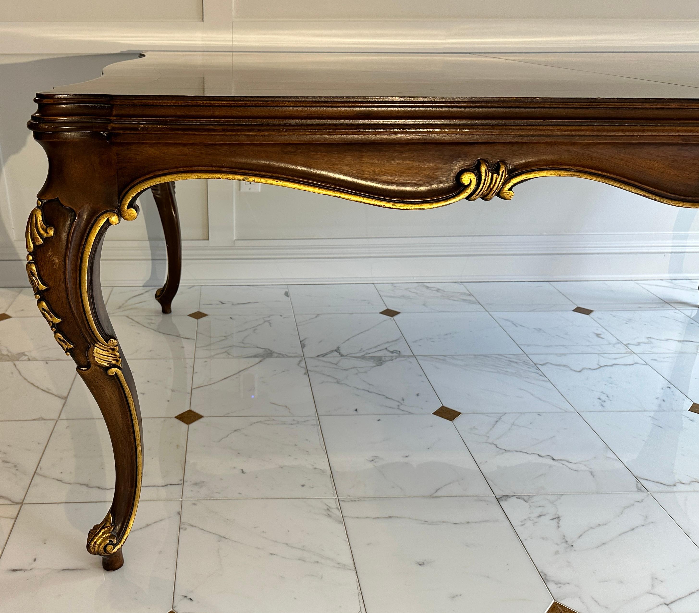 Fine and large Karges Louis XVI style carved dining table. Cabriole legs with carved and gilt leaf details. carved rolled apron edge with gilding.
47