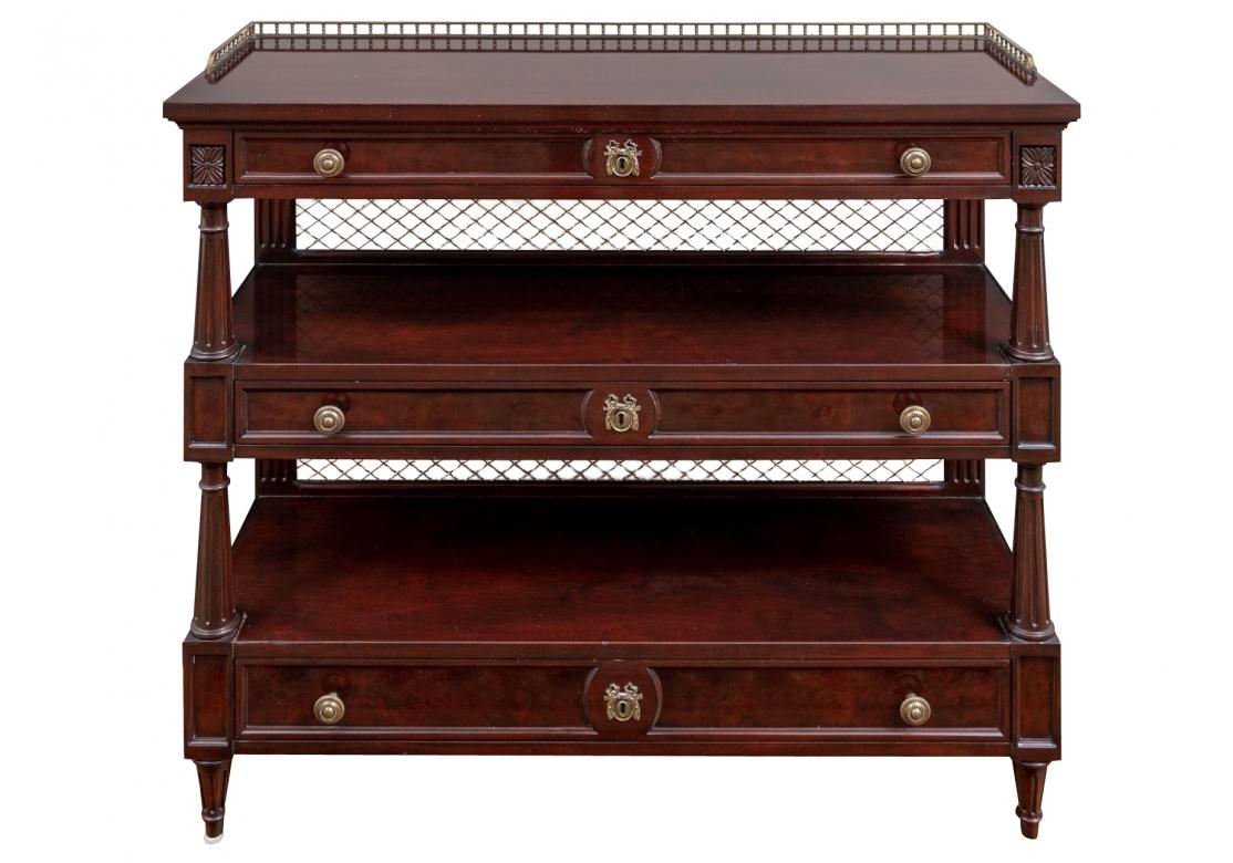 Karges mahogany three drawers, three tier server featuring antiqued brass gallery on top and brass mesh back with three drawers with antiqued brass pulls and decorative escutcheon on each drawer with round tapered fluted side rails. 
46